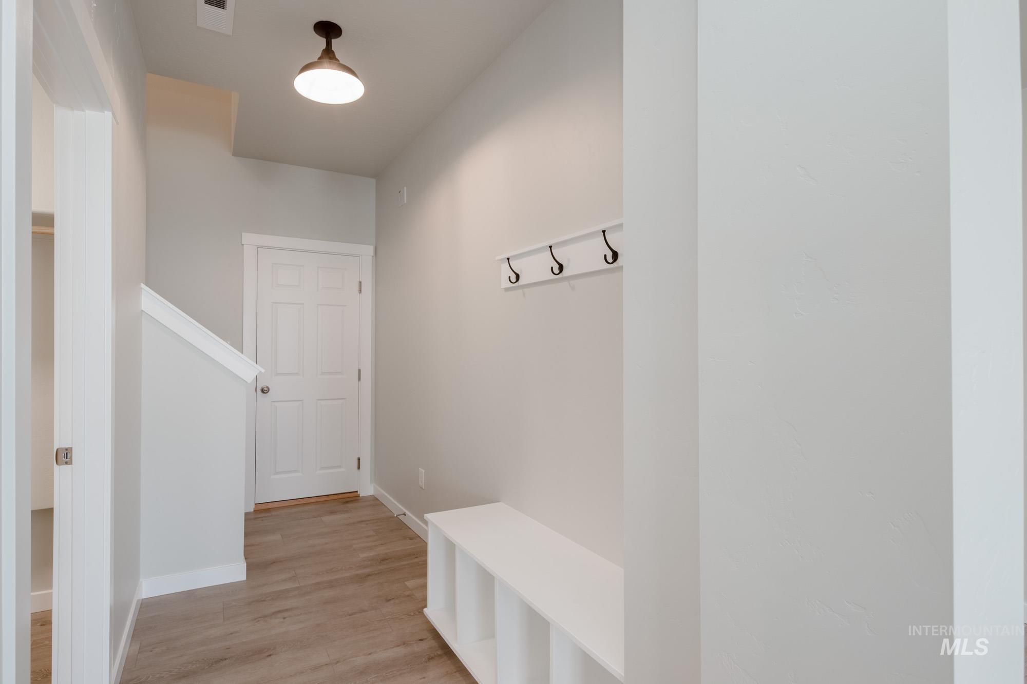 Mudroom featuring light wood-style floors and baseboards
