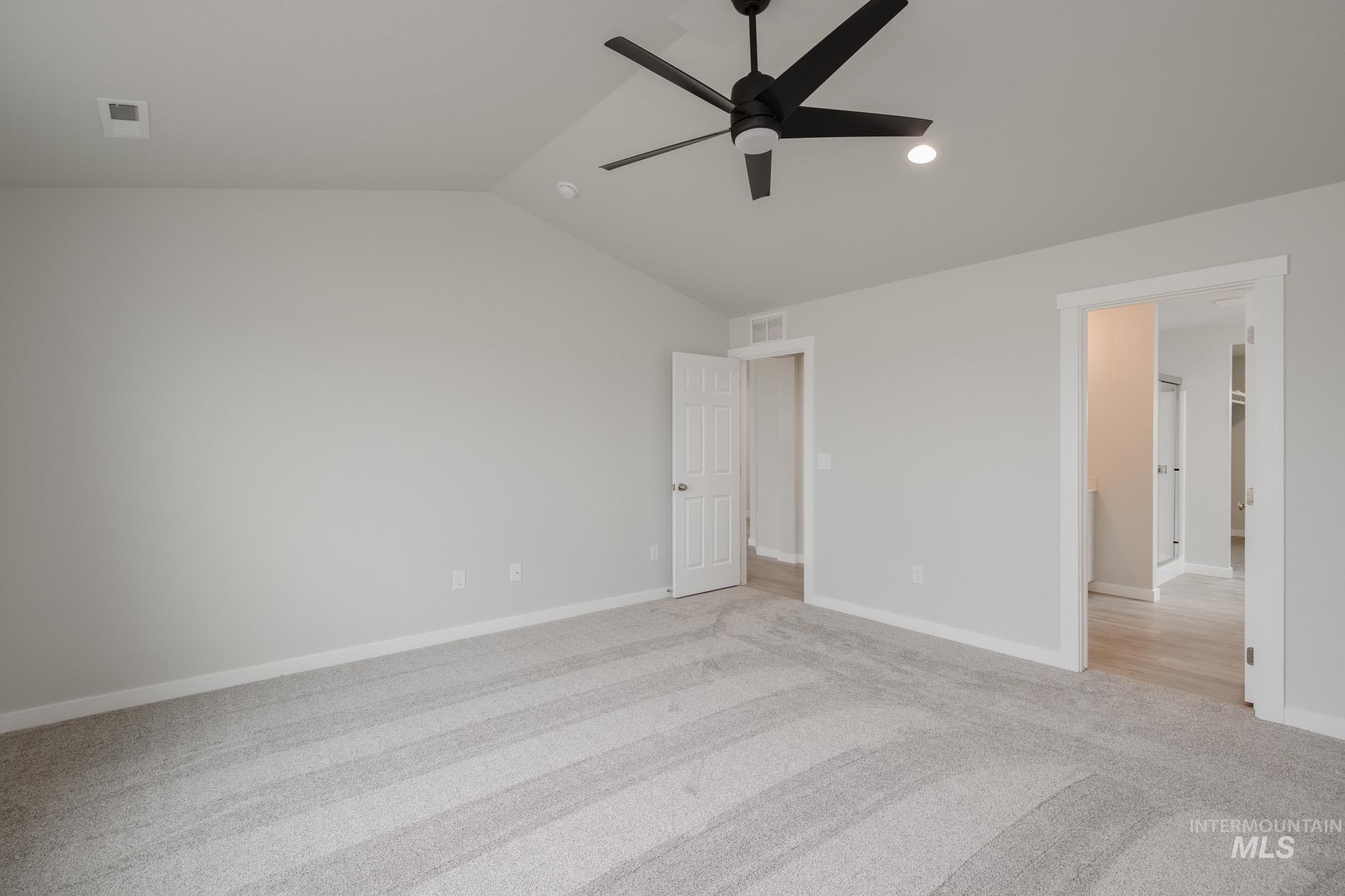 Unfurnished bedroom with vaulted ceiling, a ceiling fan, light colored carpet, and recessed lighting