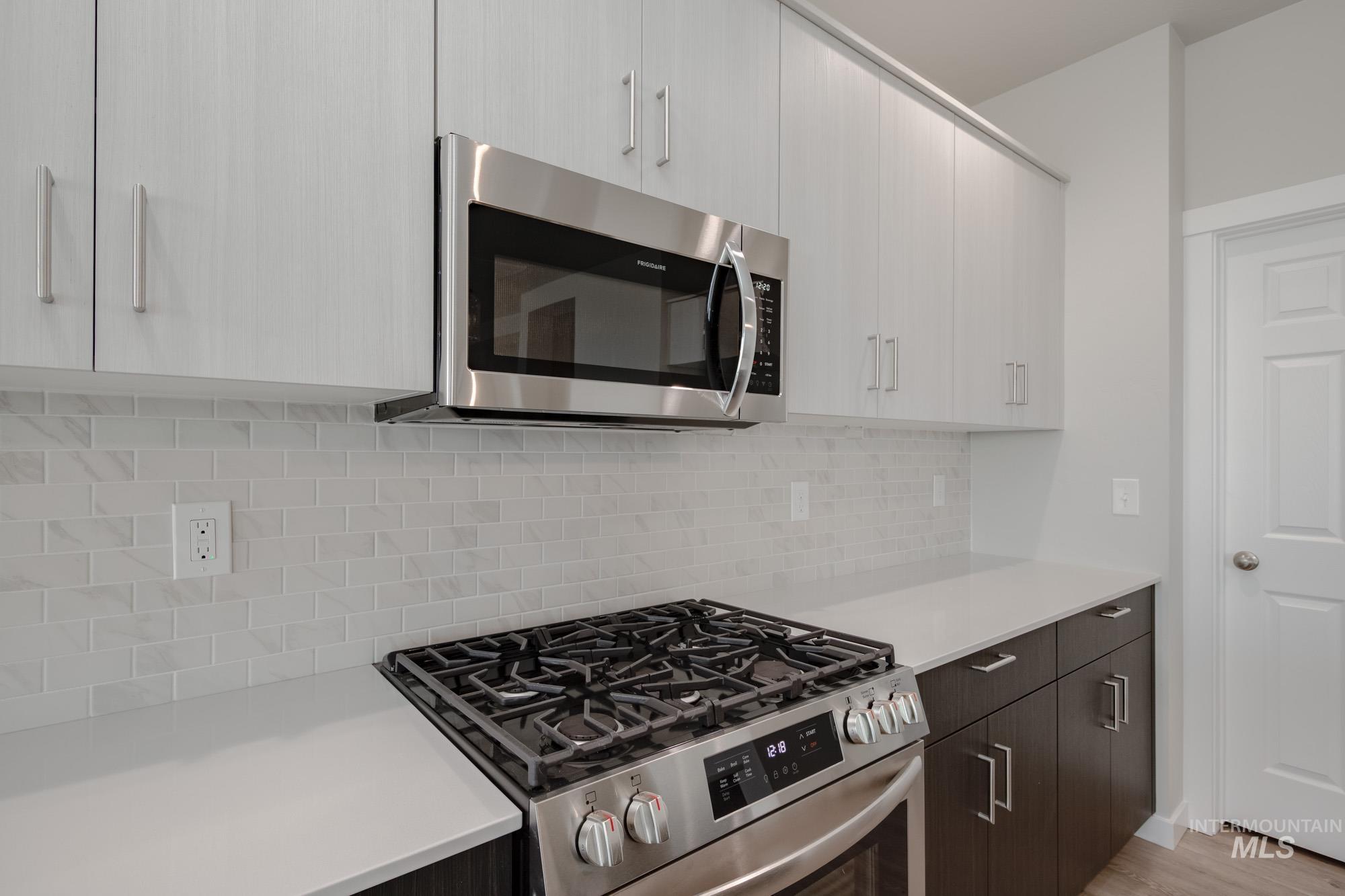 Kitchen with stainless steel appliances, modern cabinets, and decorative backsplash