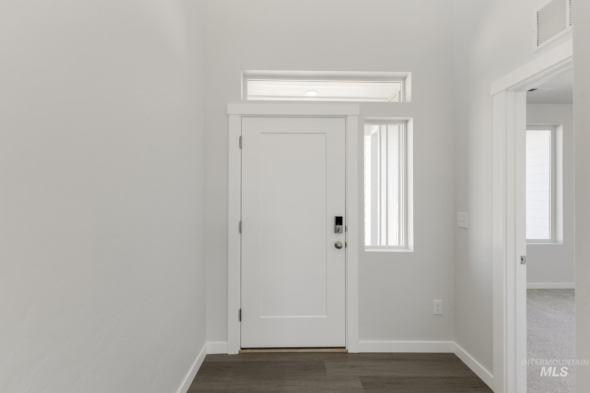 Entrance foyer featuring baseboards and dark wood-style floors