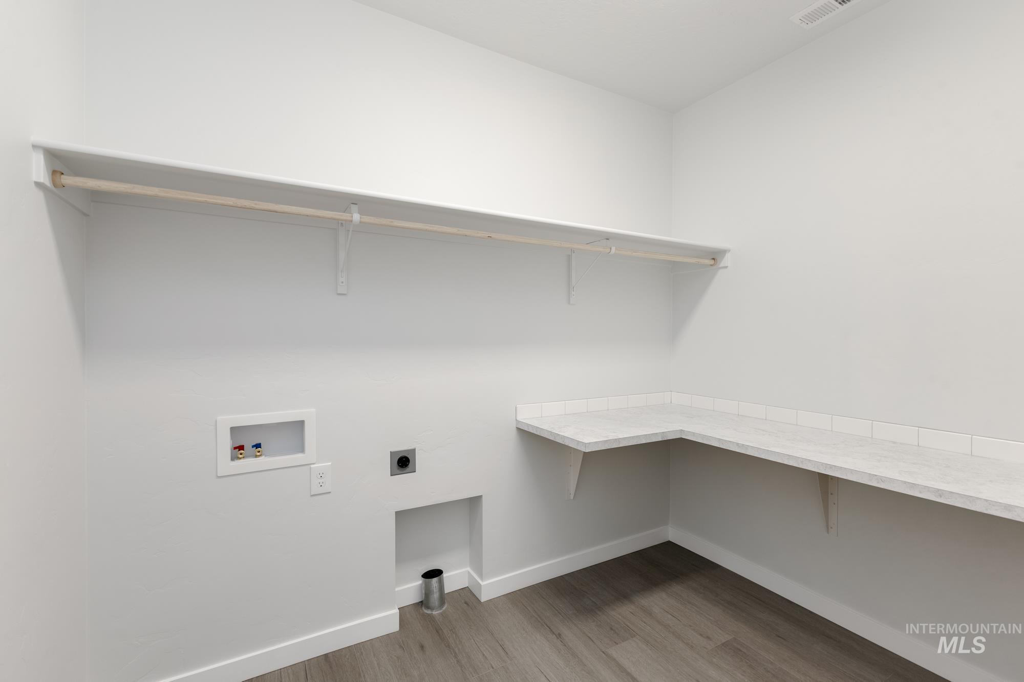 Laundry room with light wood-style floors, hookup for an electric dryer, and washer hookup