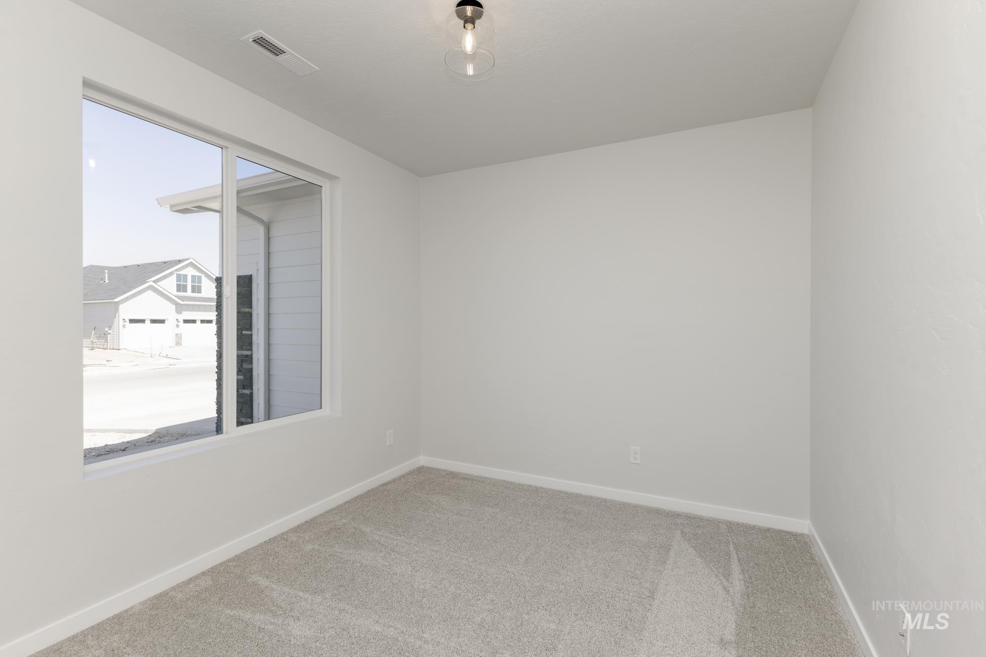 Empty room featuring light colored carpet and baseboards
