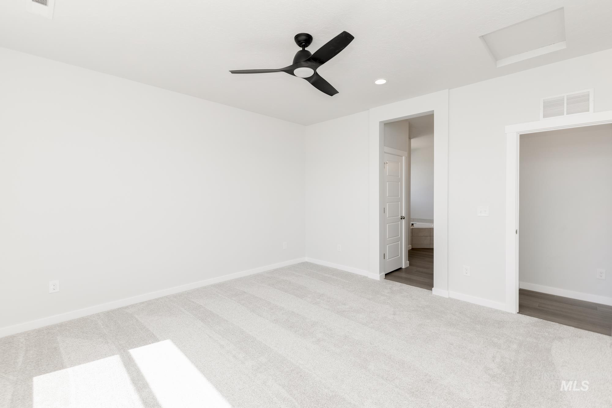 Unfurnished bedroom with attic access, carpet floors, a ceiling fan, recessed lighting, and ensuite bathroom