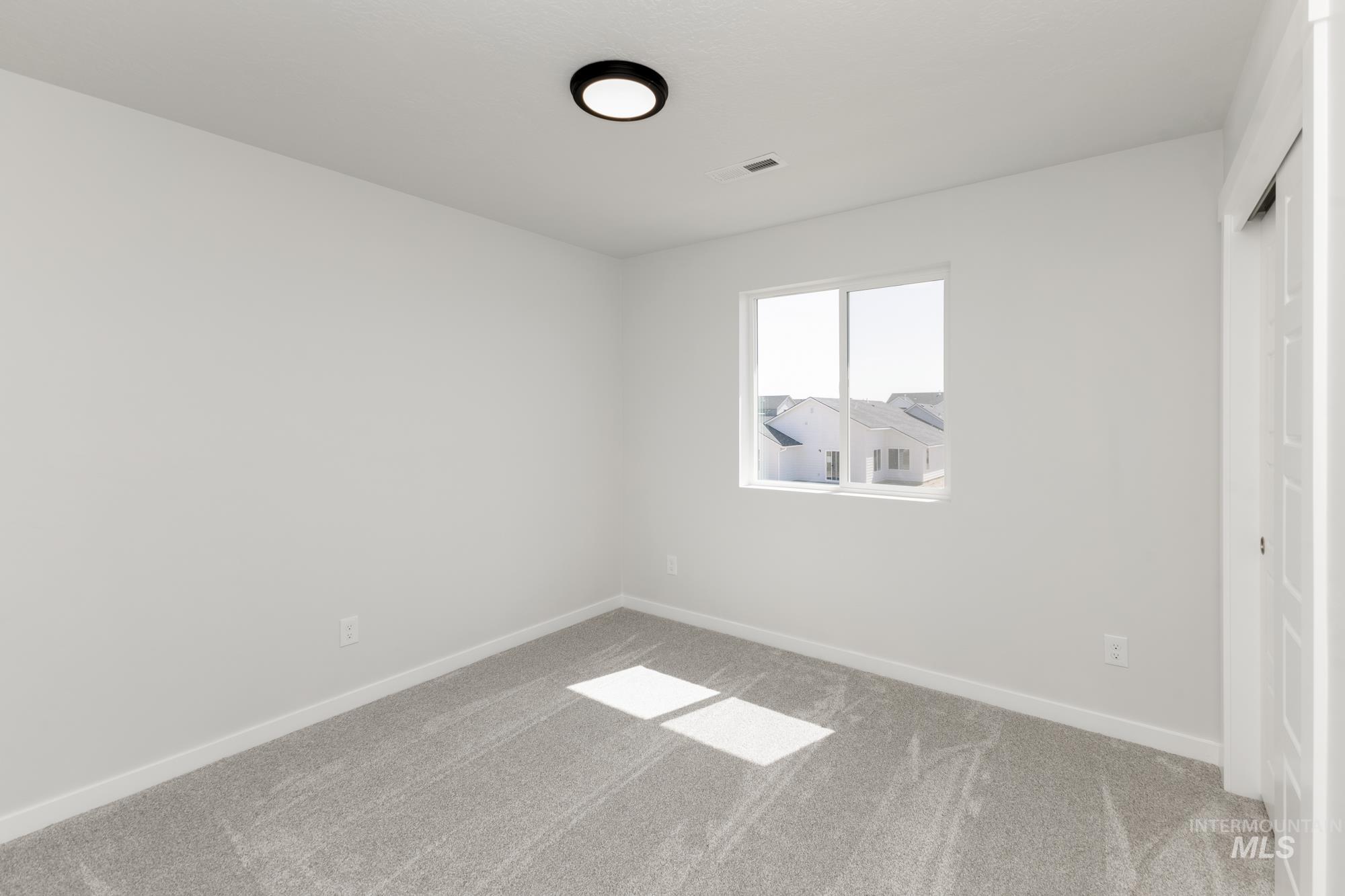 Carpeted empty room with baseboards