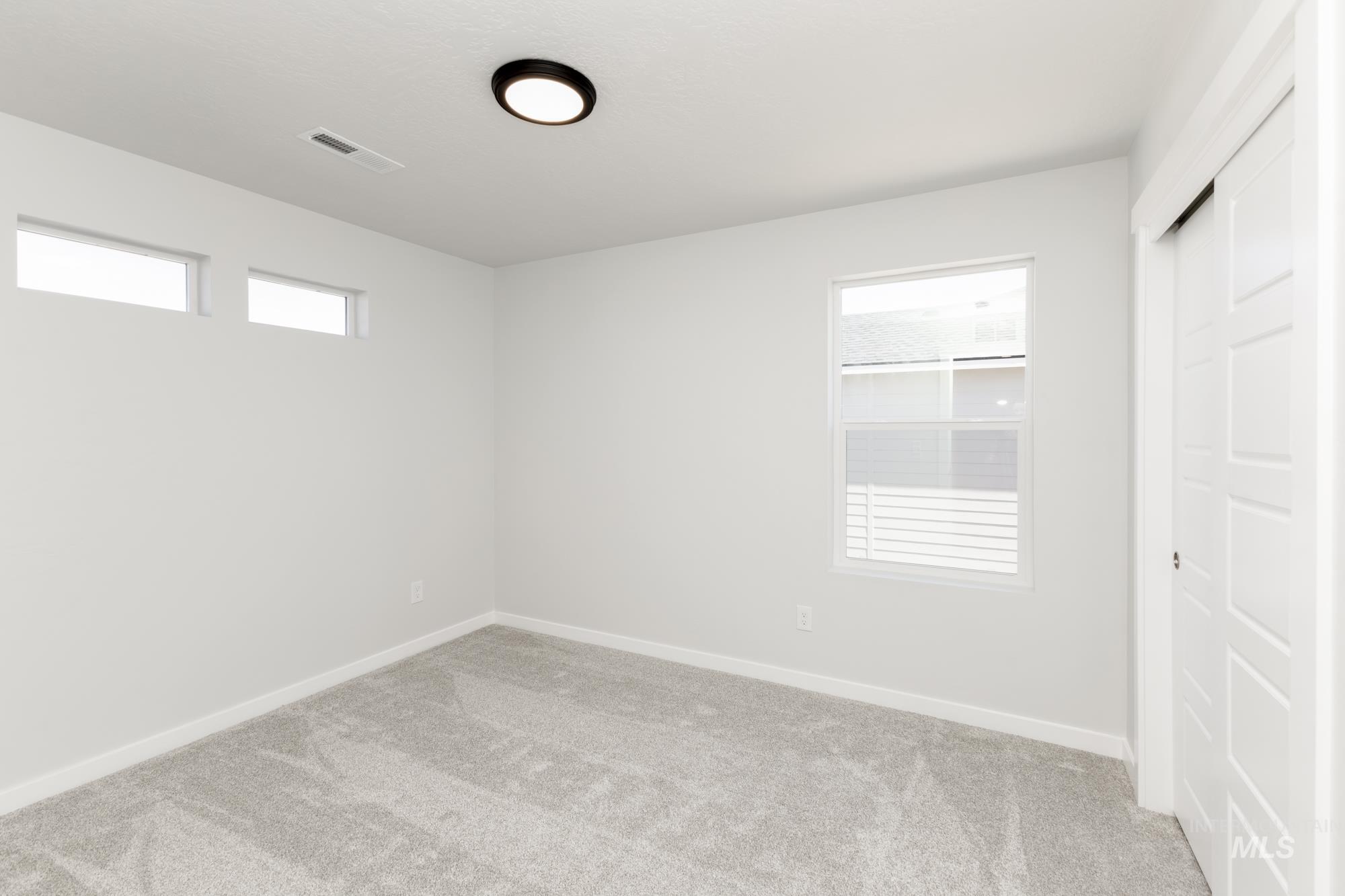 Empty room featuring carpet floors and plenty of natural light