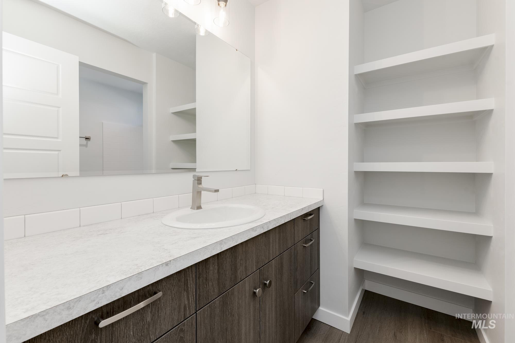 Half bathroom featuring vanity and dark wood-style floors