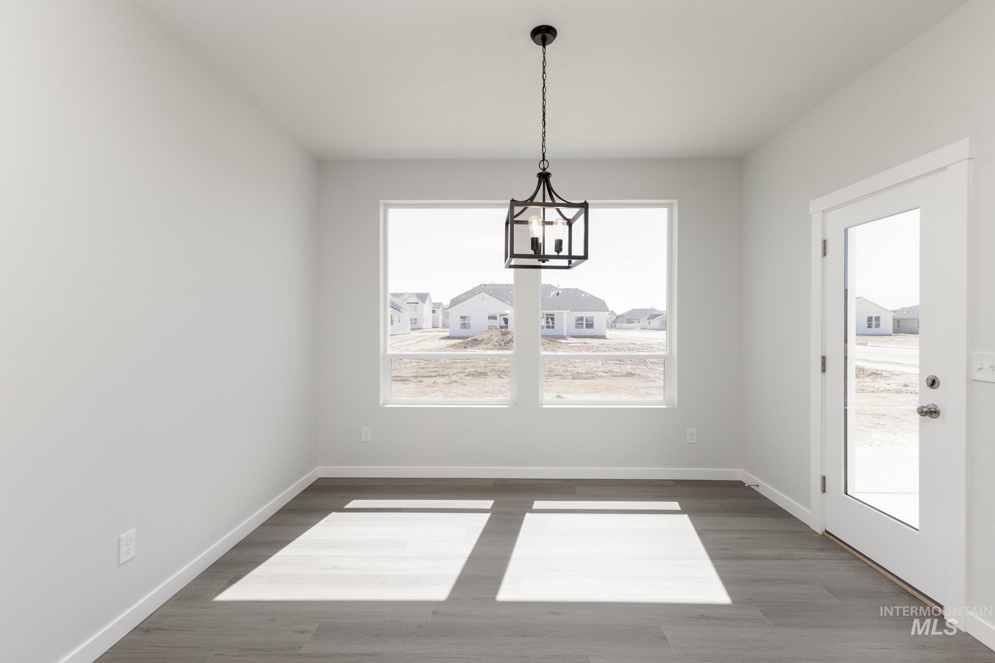 Unfurnished dining area with wood finished floors and a chandelier