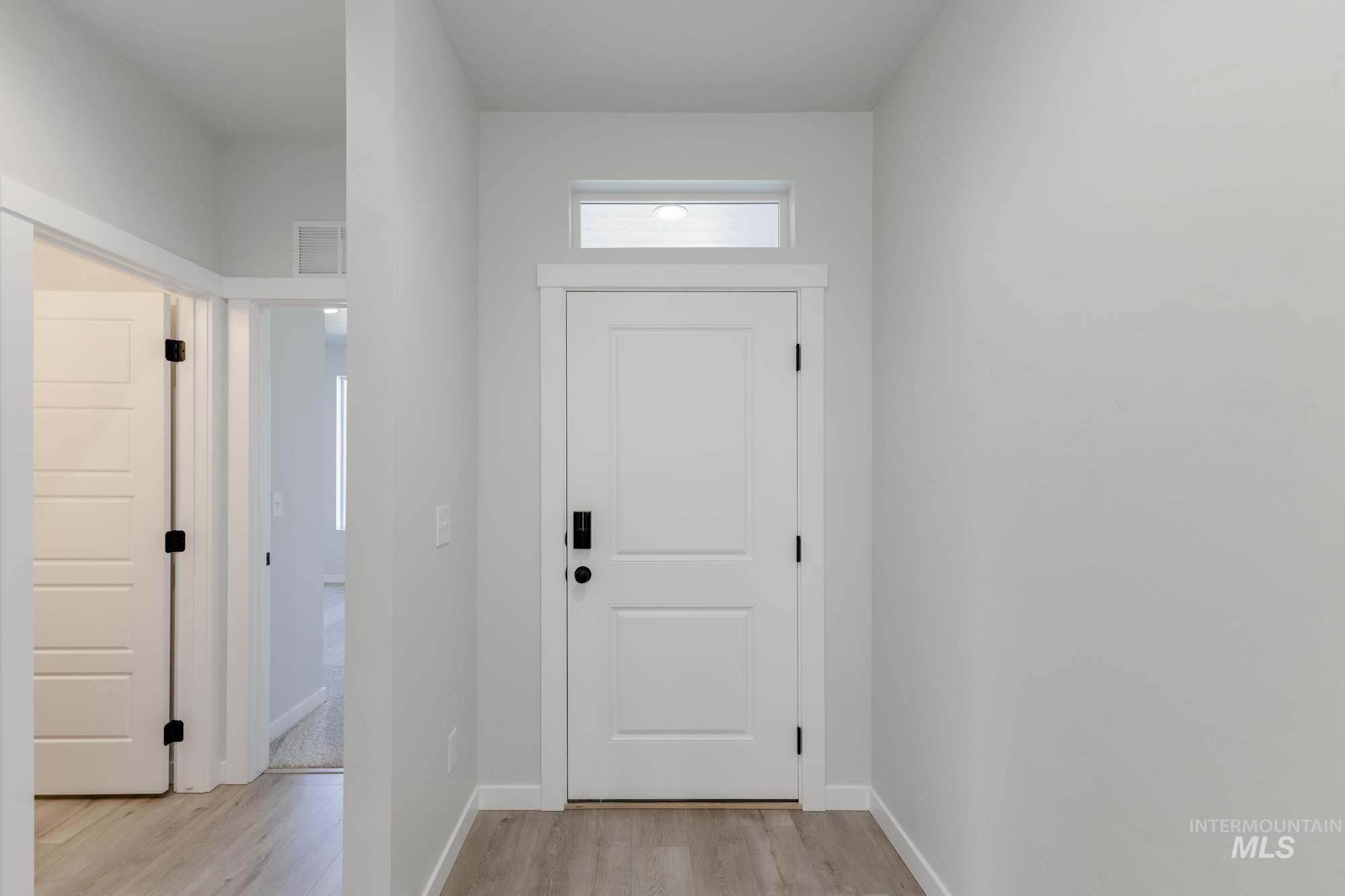 Foyer featuring light wood-style floors and baseboards