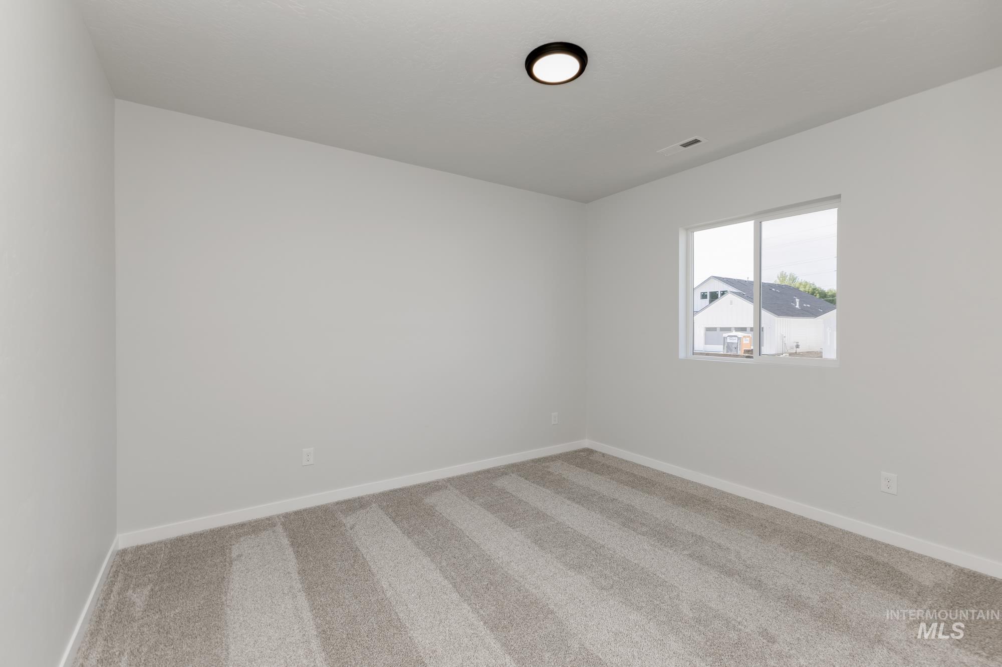 Empty room with carpet and baseboards