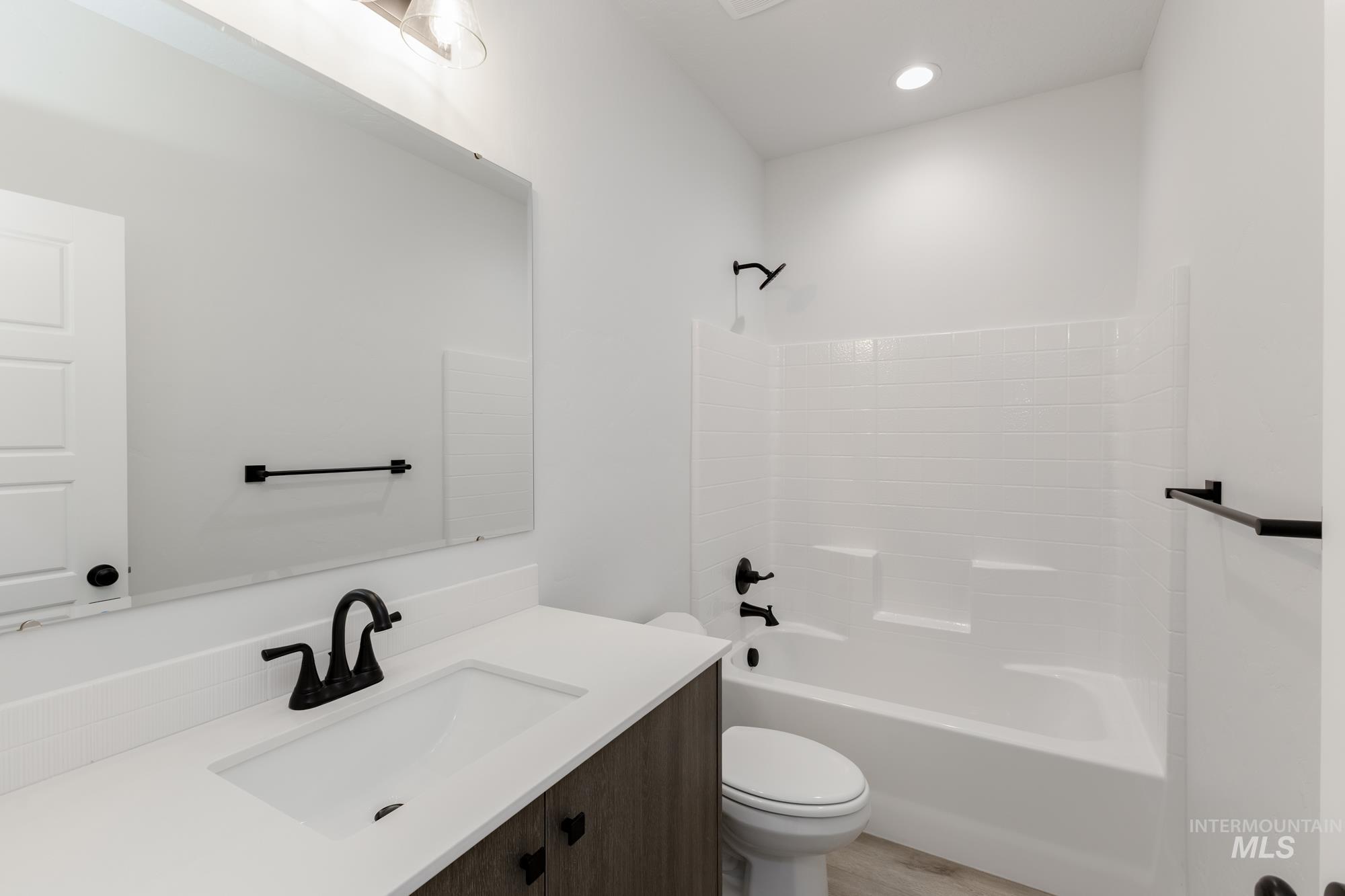 Bathroom featuring vanity, bathing tub / shower combination, recessed lighting, and light wood-style floors