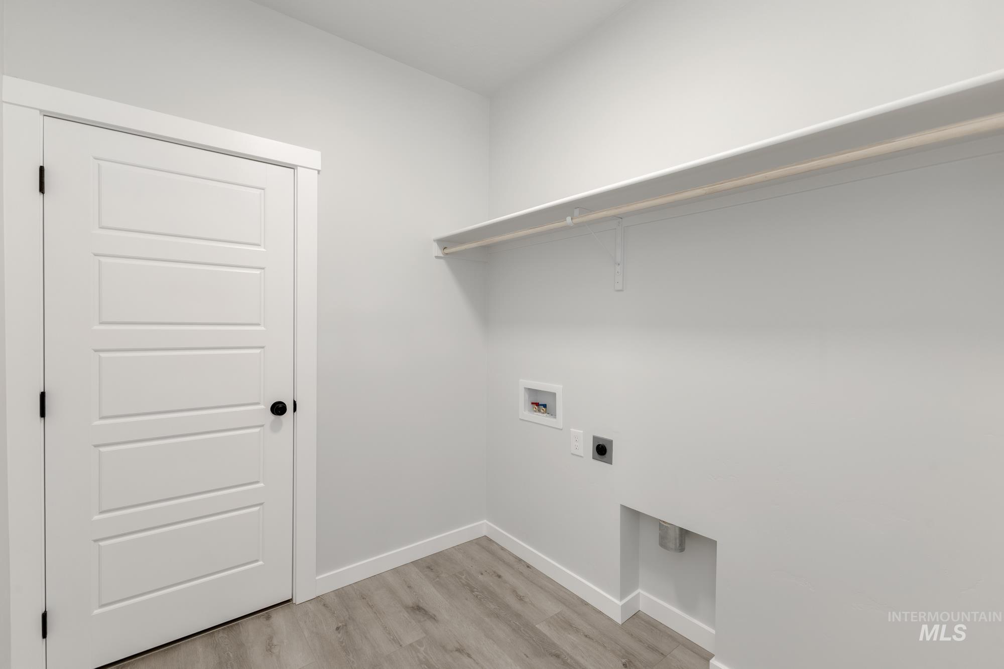Laundry area featuring light wood-style floors, hookup for a washing machine, and electric dryer hookup