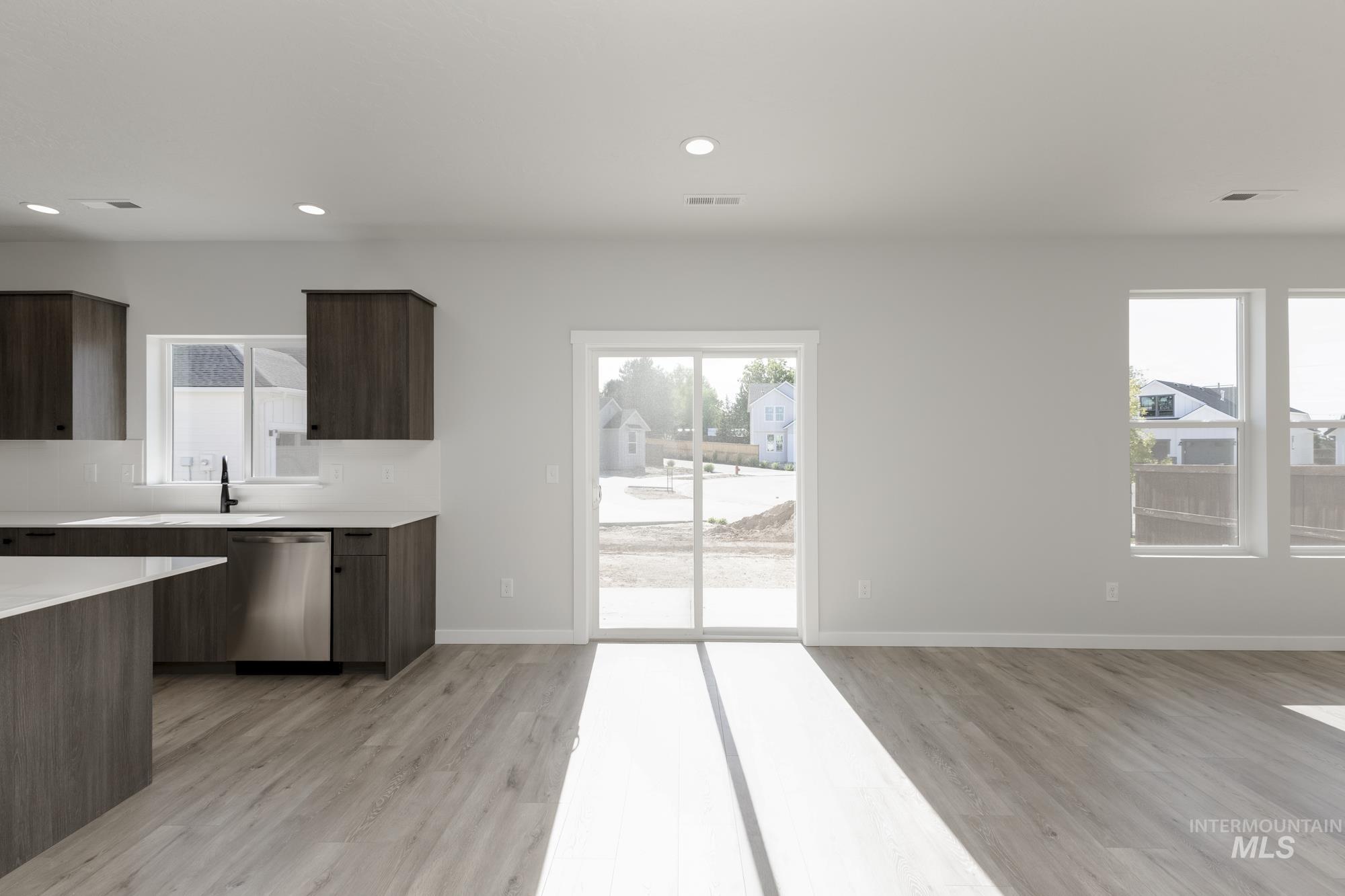 Kitchen with modern cabinets, dishwasher, recessed lighting, light wood-style floors, and dark brown cabinetry
