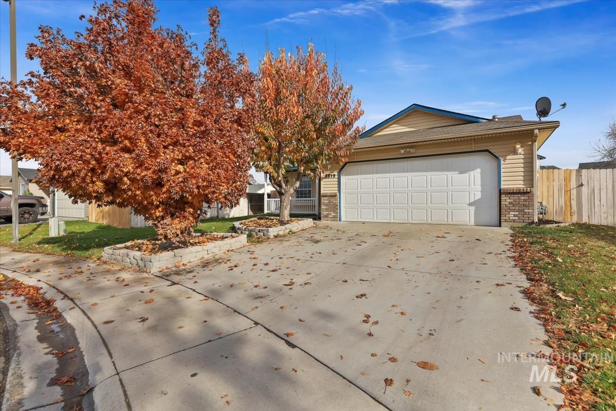View of front of property featuring concrete driveway, brick siding, and a garage