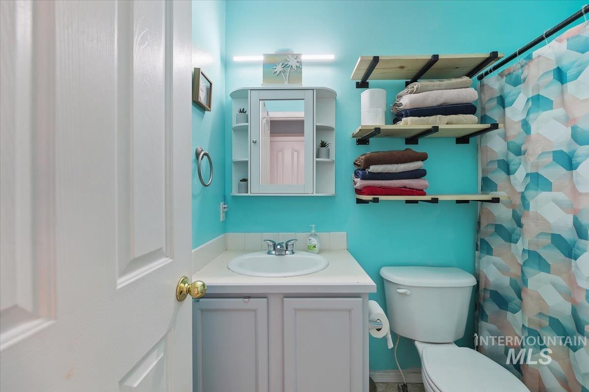 Bathroom with a shower with shower curtain and vanity