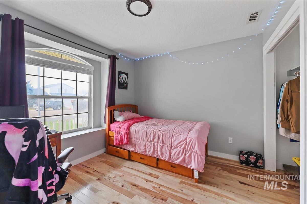 Bedroom featuring light wood-style floors and a closet