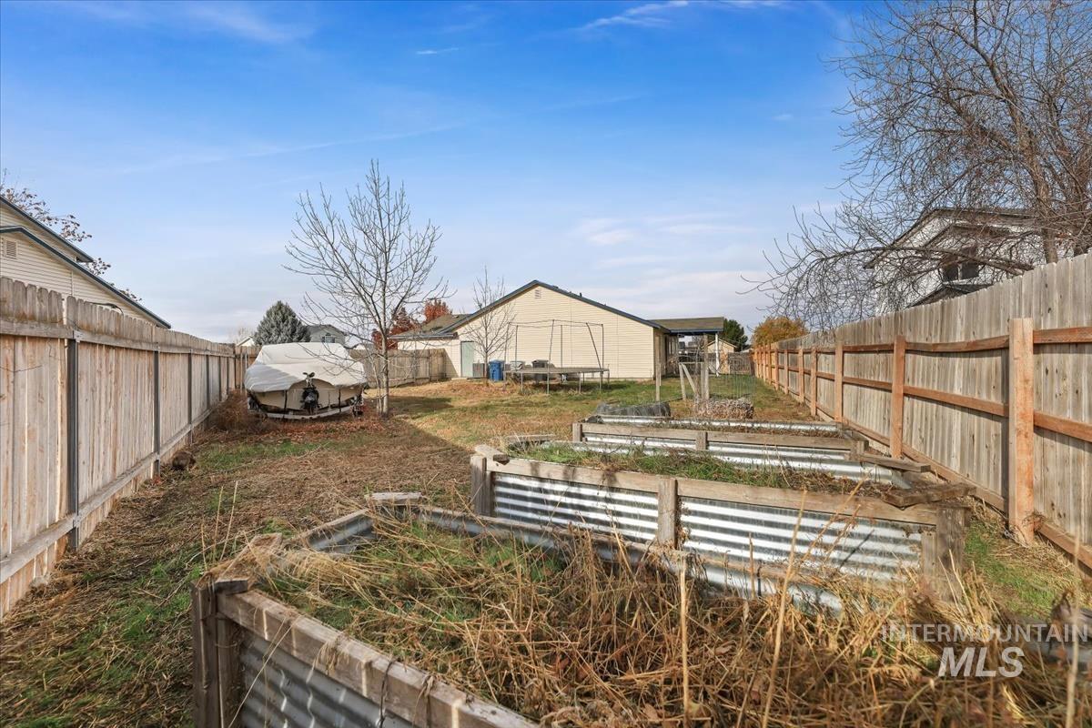Fenced backyard with a vegetable garden