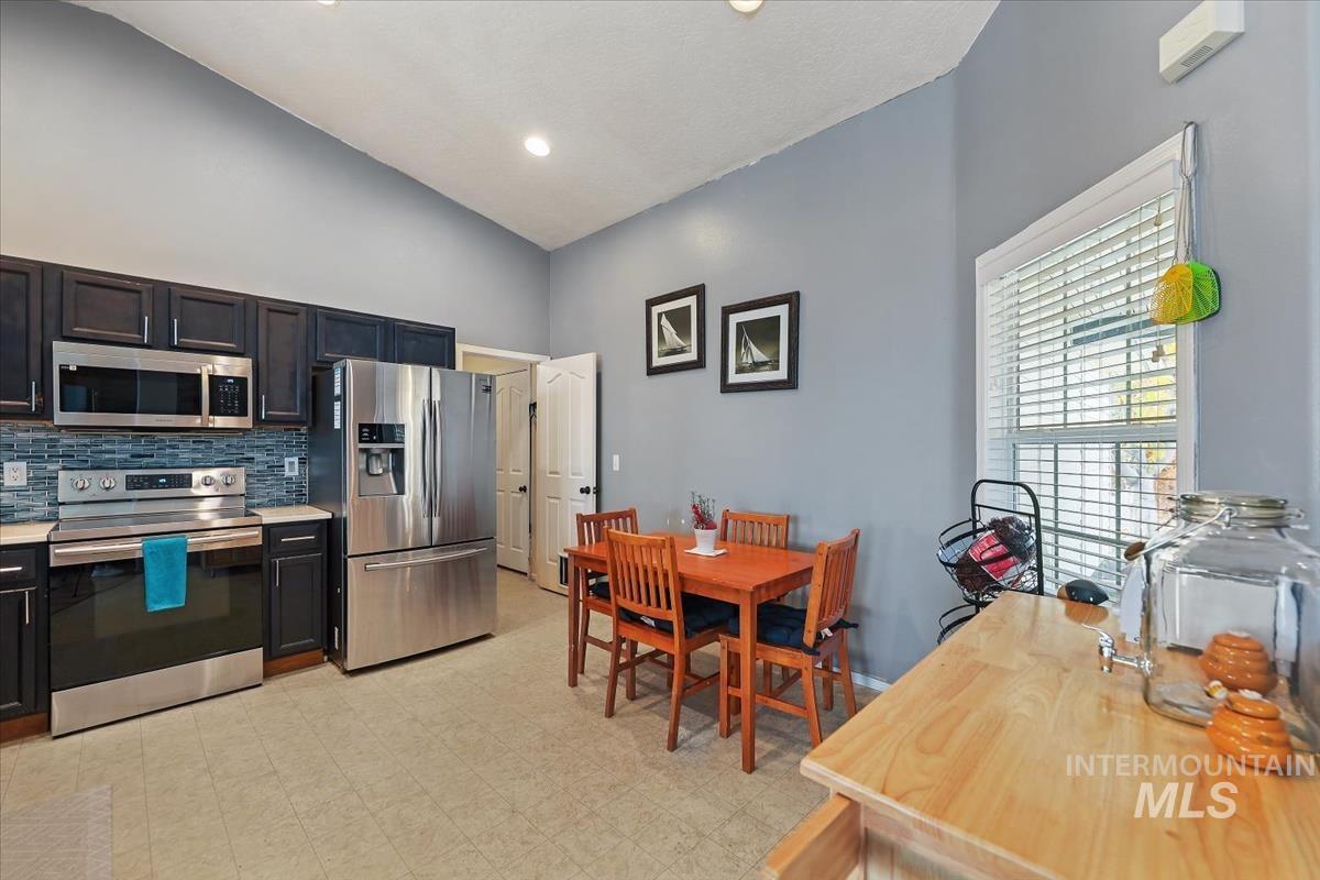 Kitchen featuring stainless steel appliances, light countertops, decorative backsplash, light flooring, and recessed lighting