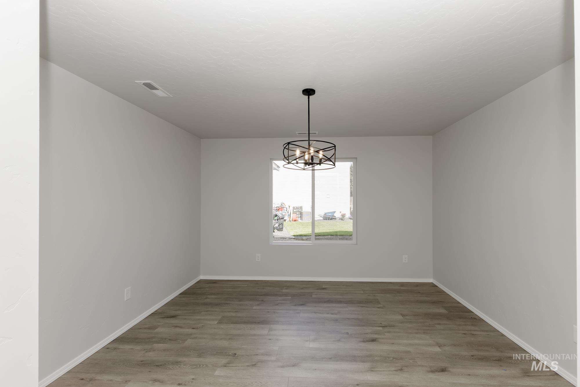 Unfurnished dining area featuring a chandelier and light wood-style flooring