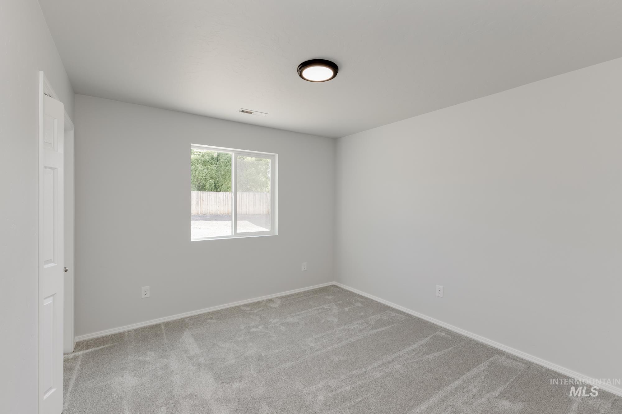 Carpeted empty room featuring baseboards