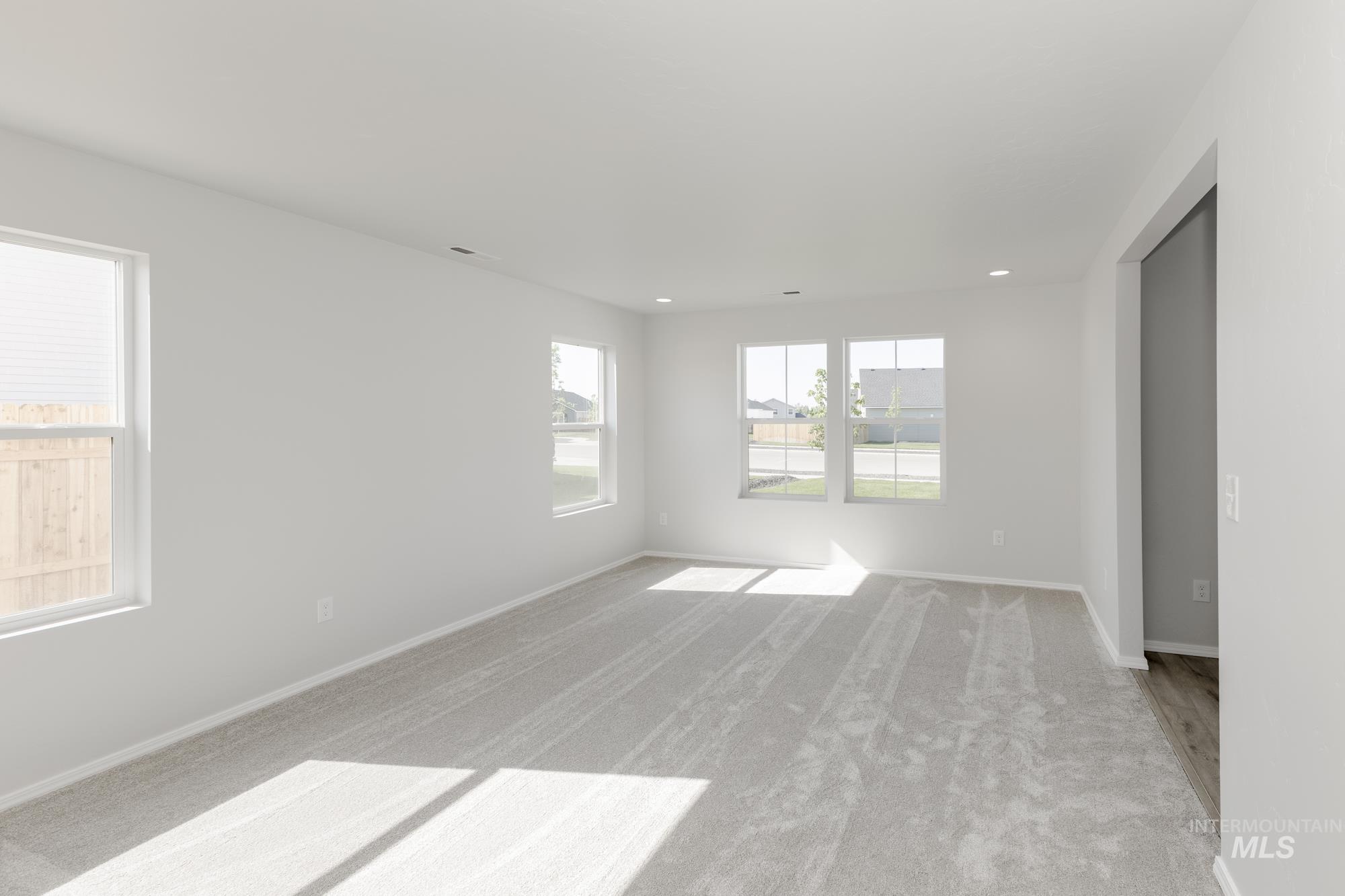 Carpeted empty room with baseboards and recessed lighting