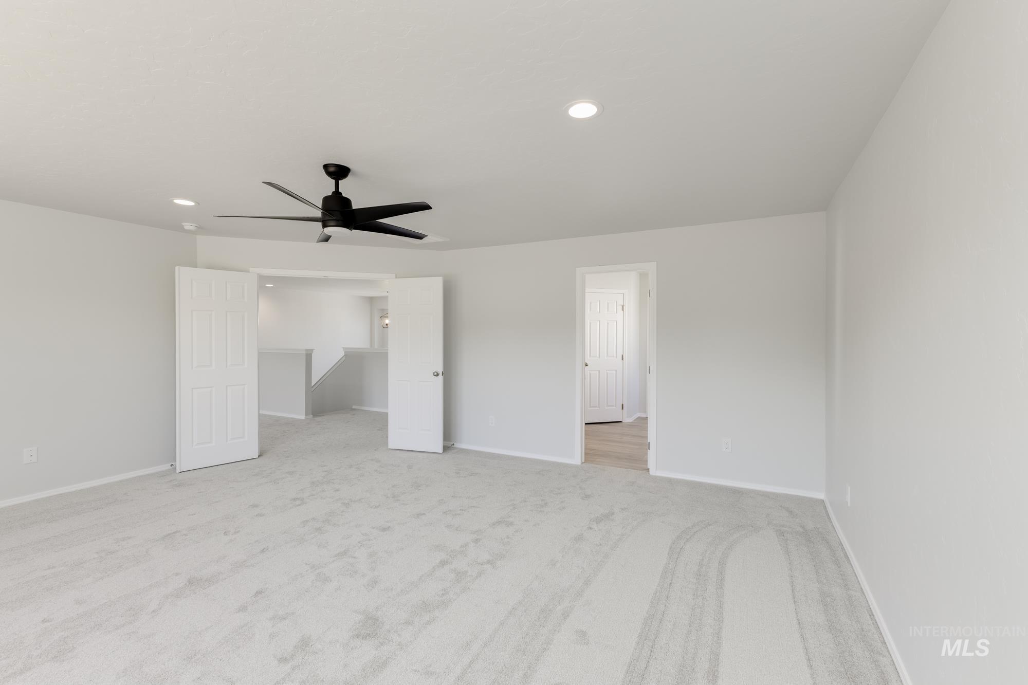 Unfurnished bedroom featuring light carpet, recessed lighting, and a ceiling fan