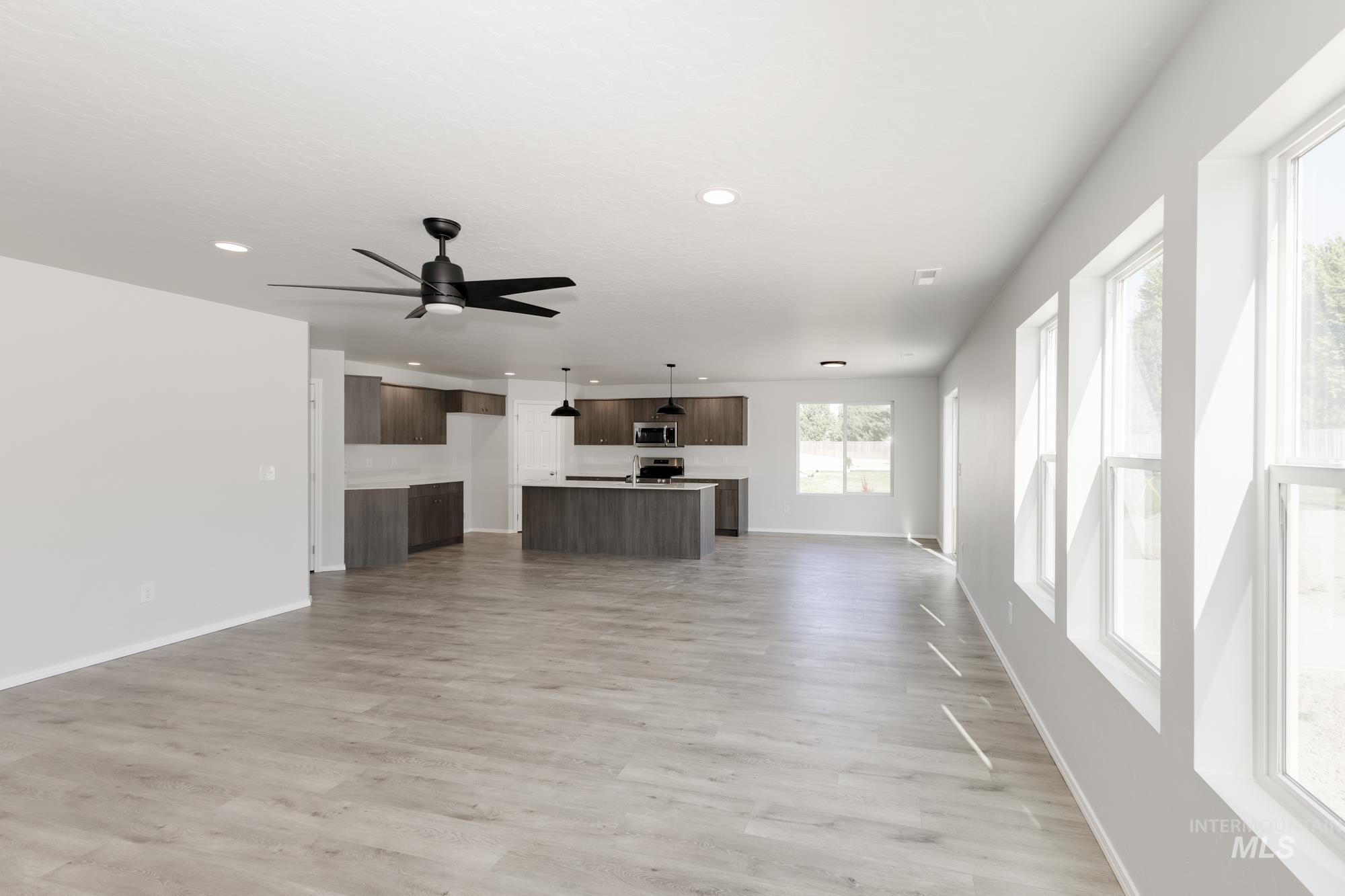 Unfurnished living room featuring light wood-style floors, recessed lighting, and a ceiling fan
