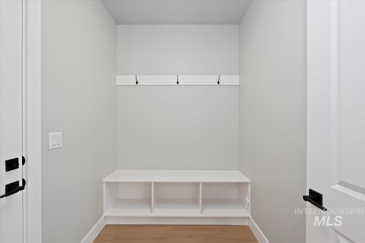 Mudroom featuring light wood finished floors and baseboards