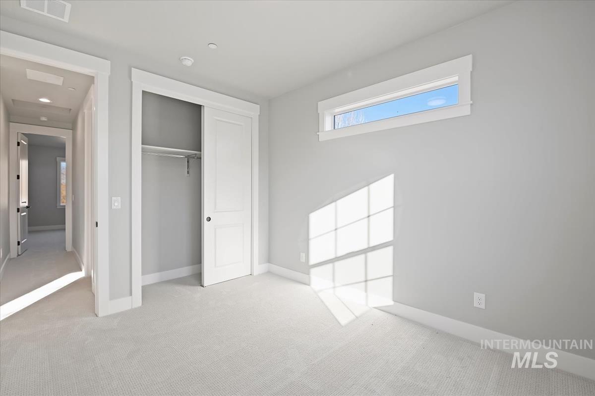 Unfurnished bedroom featuring carpet and a closet