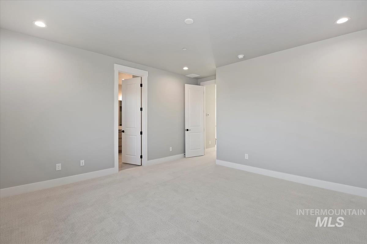 Unfurnished bedroom with recessed lighting and light carpet