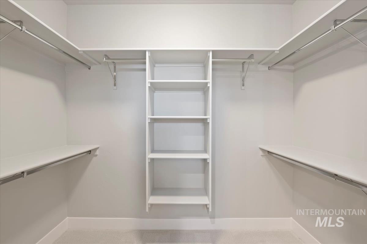 Walk in closet with light colored carpet