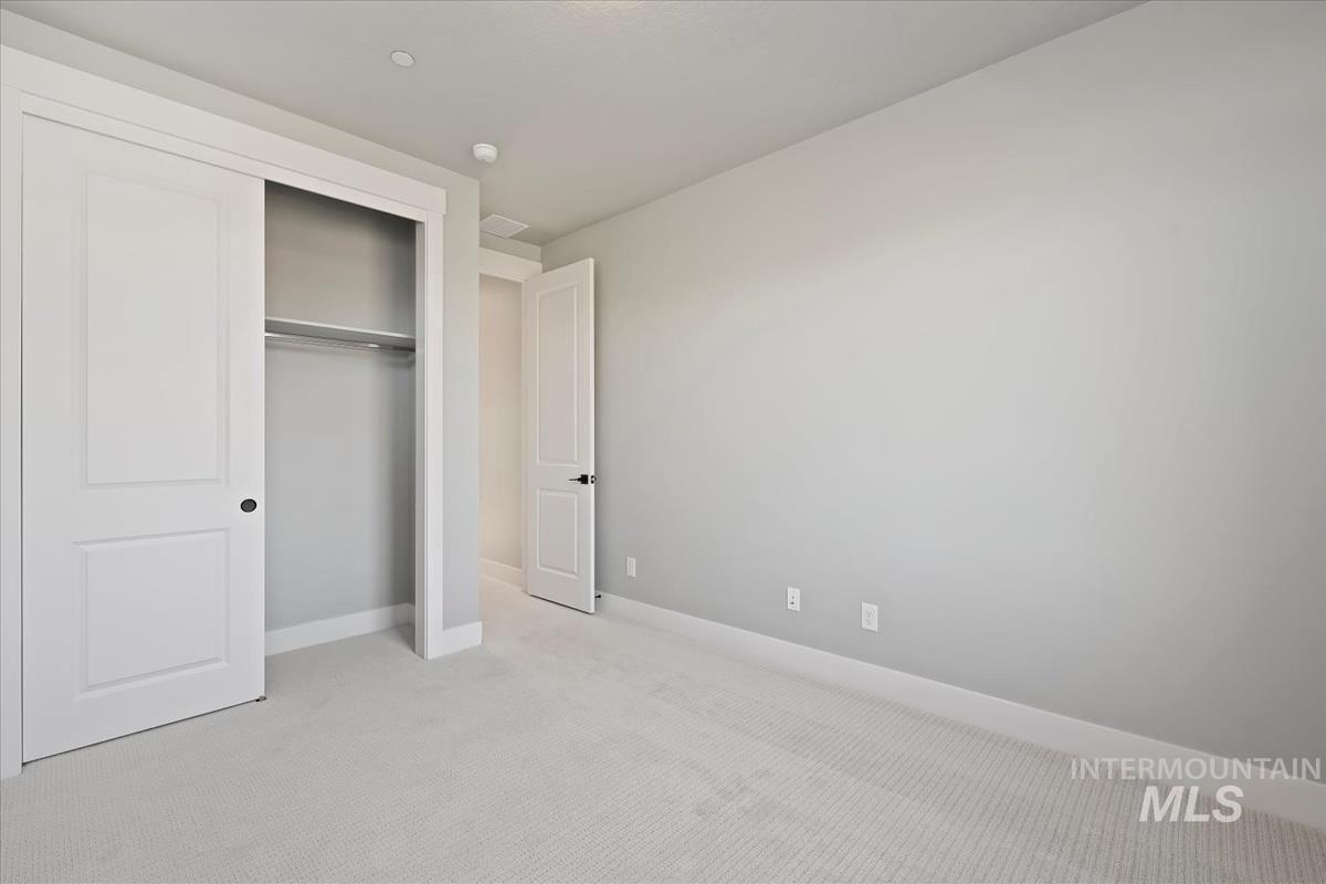 Unfurnished bedroom featuring carpet flooring and a closet