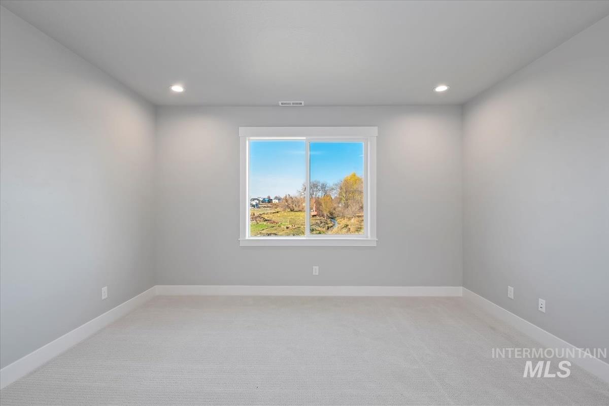 Spare room featuring light carpet and recessed lighting