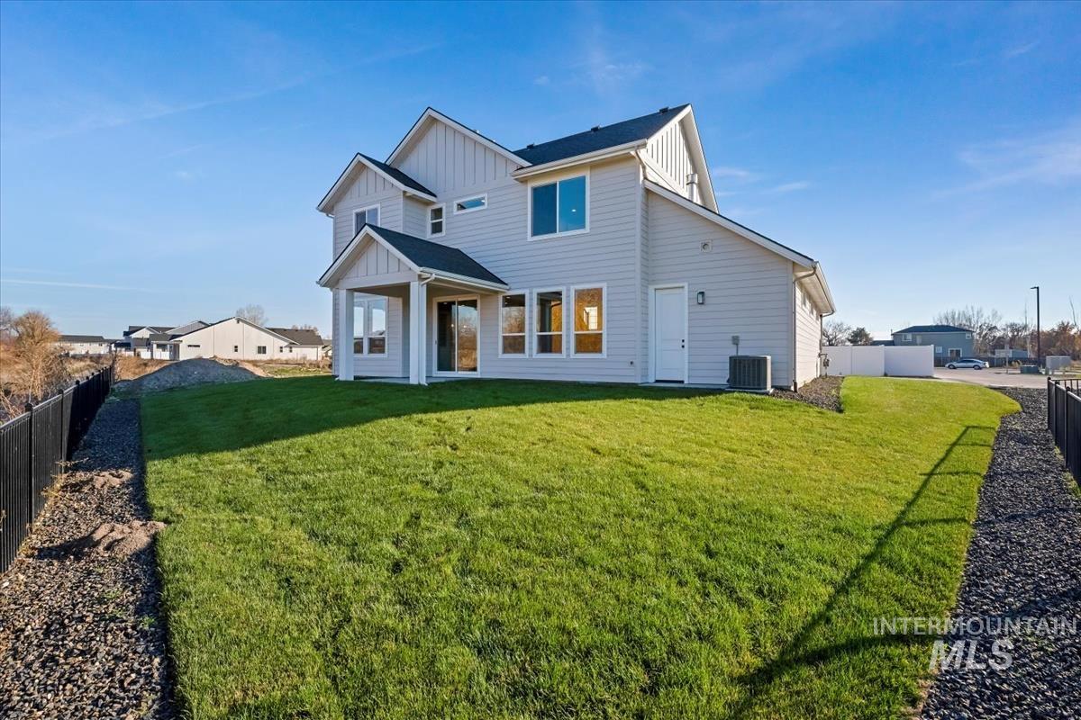 Back of property featuring board and batten siding, a fenced backyard, and a patio