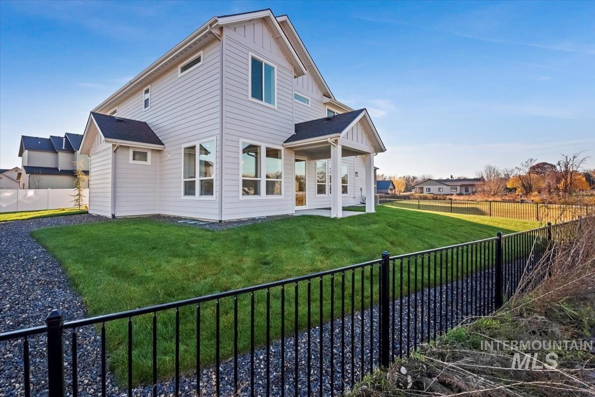 Back of property featuring a fenced backyard, a patio, and board and batten siding