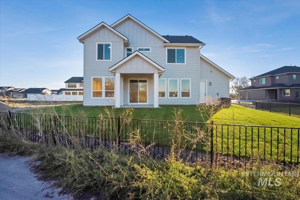 View of front of house with board and batten siding and a fenced backyard