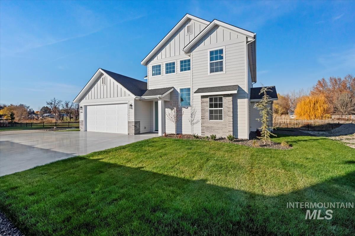 Modern inspired farmhouse with board and batten siding, concrete driveway, and an attached garage