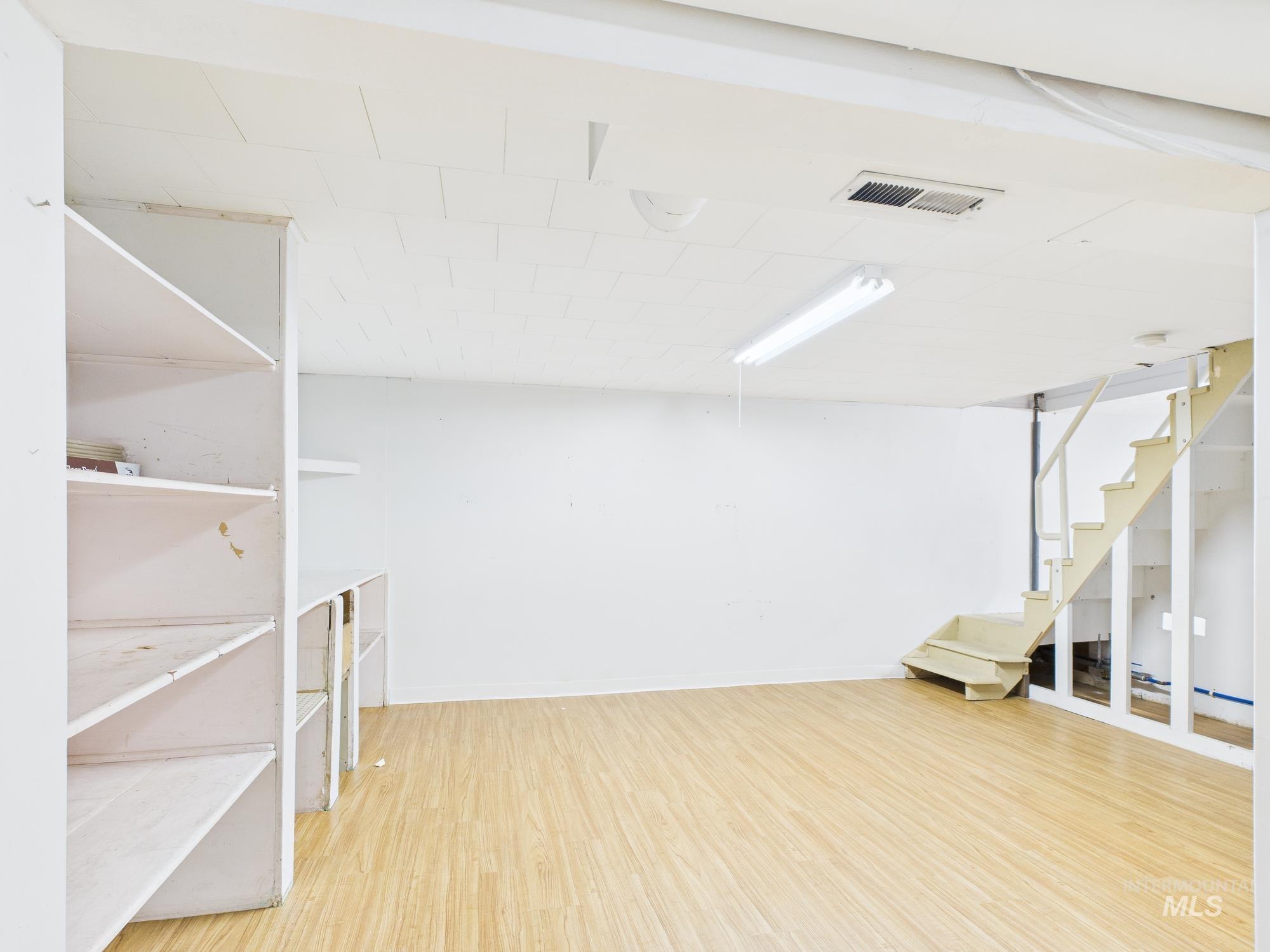 Finished below grade area with light wood finished floors and stairs