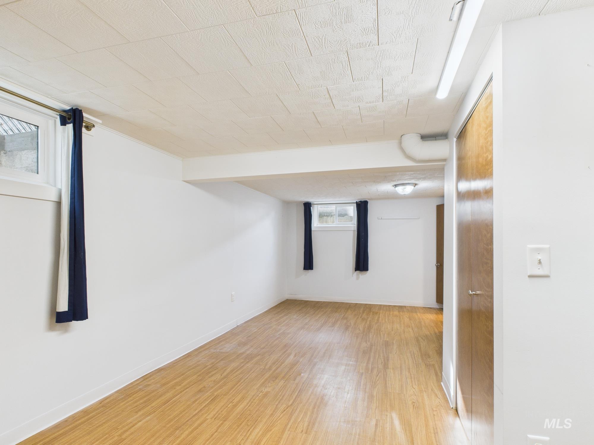 Unfurnished room with light wood-style flooring and baseboards