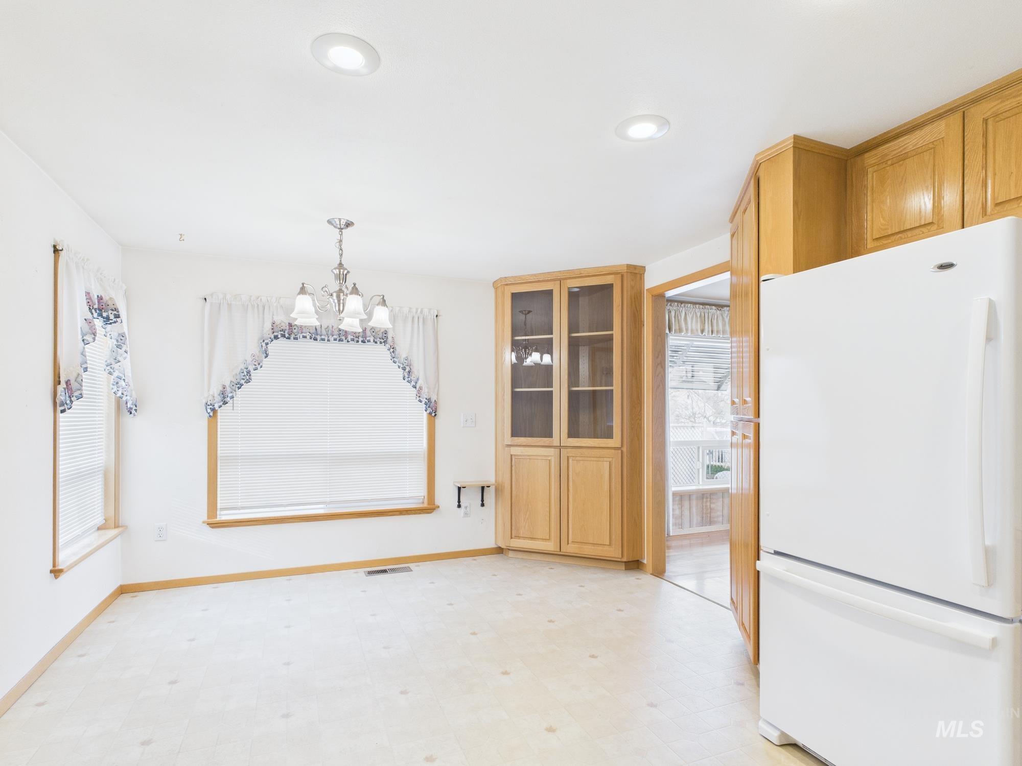 Unfurnished dining area with light flooring, a chandelier, and recessed lighting