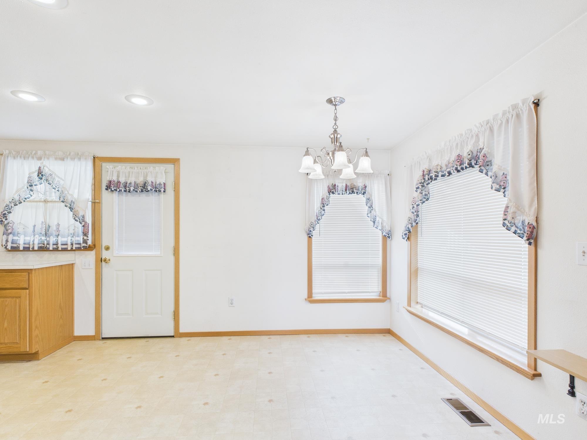 Unfurnished dining area featuring light flooring, a chandelier, plenty of natural light, and recessed lighting