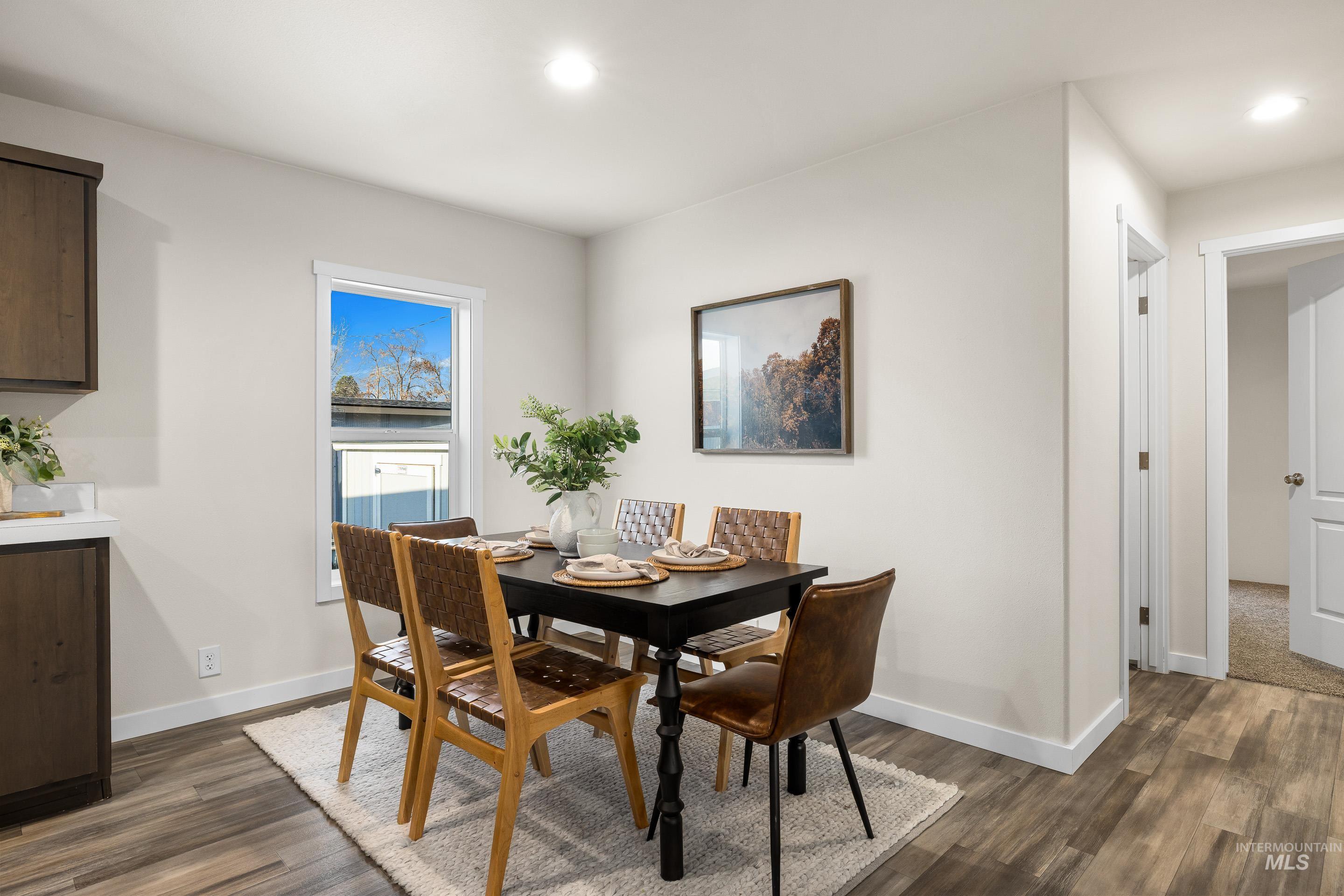 Dining room with dark wood-type flooring and recessed lighting