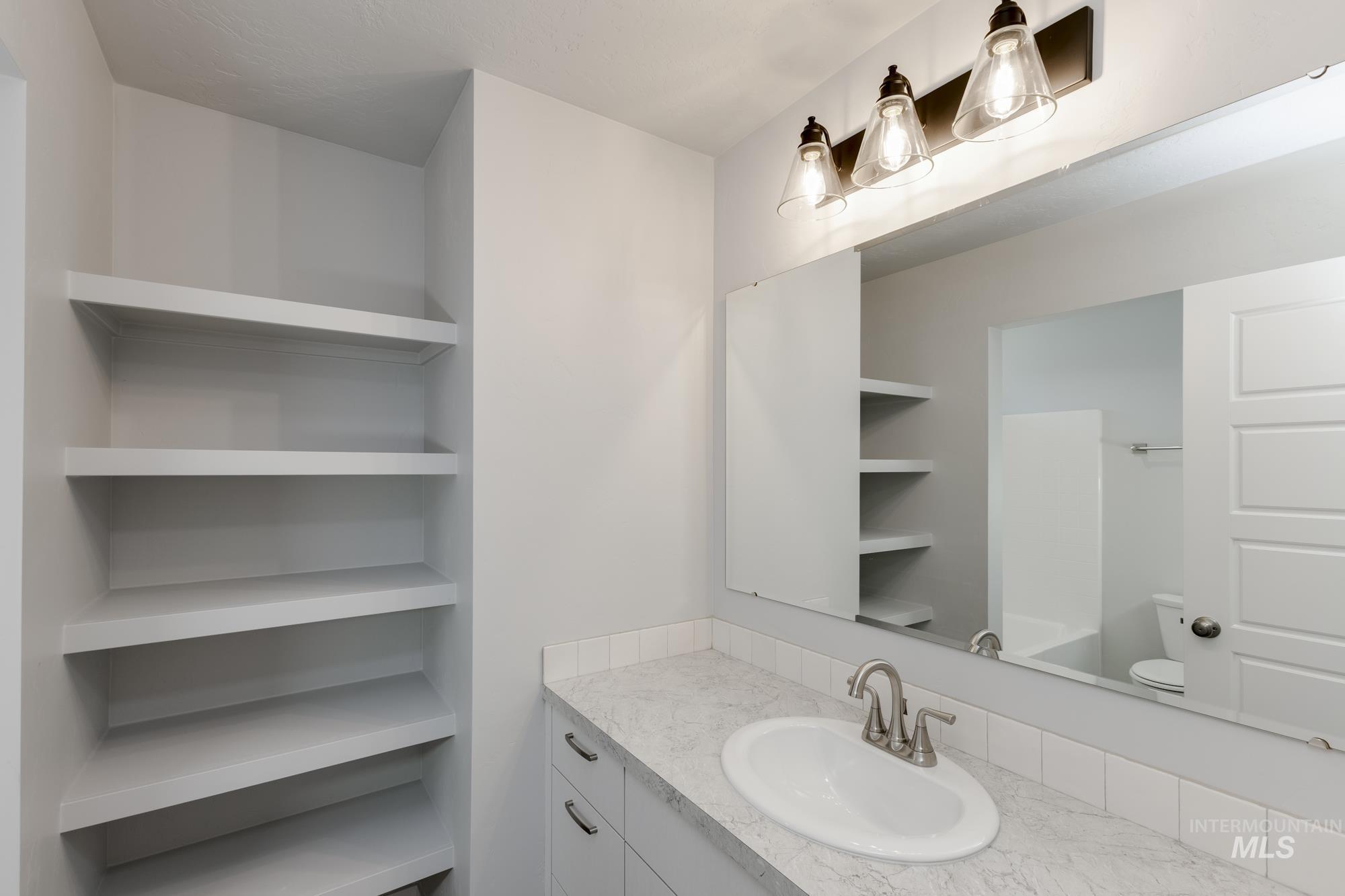 Half bathroom featuring vanity and toilet