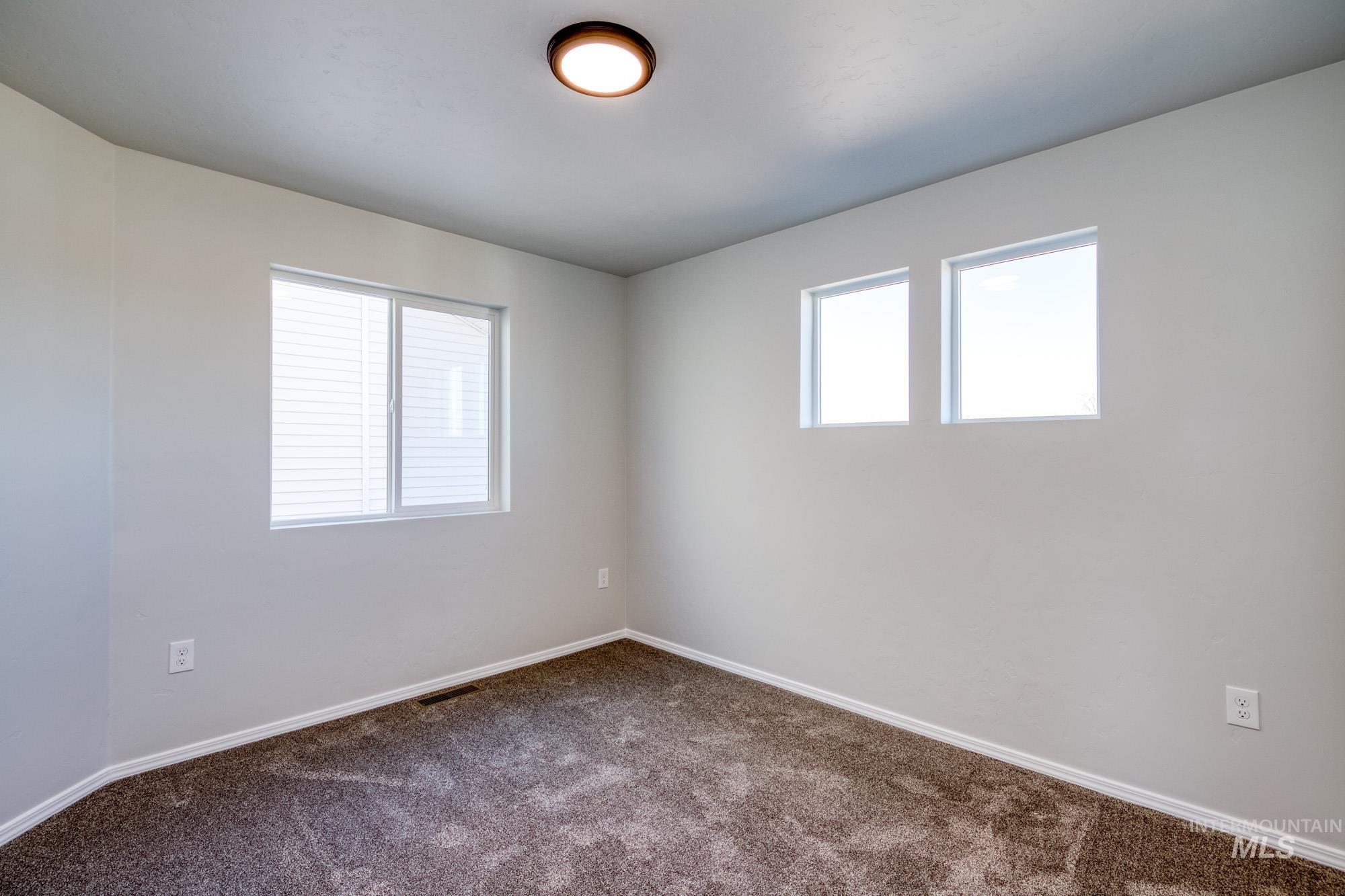 Empty room with carpet flooring and baseboards