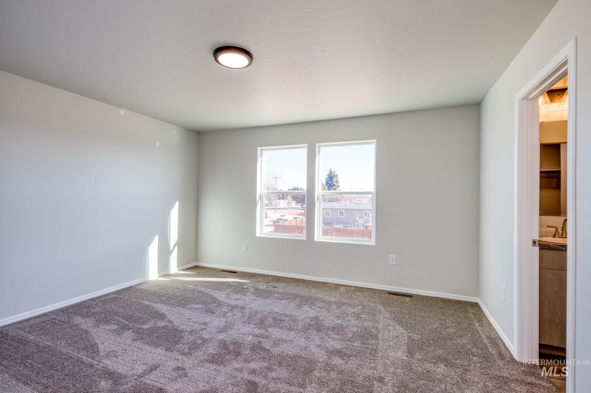 Carpeted empty room with baseboards