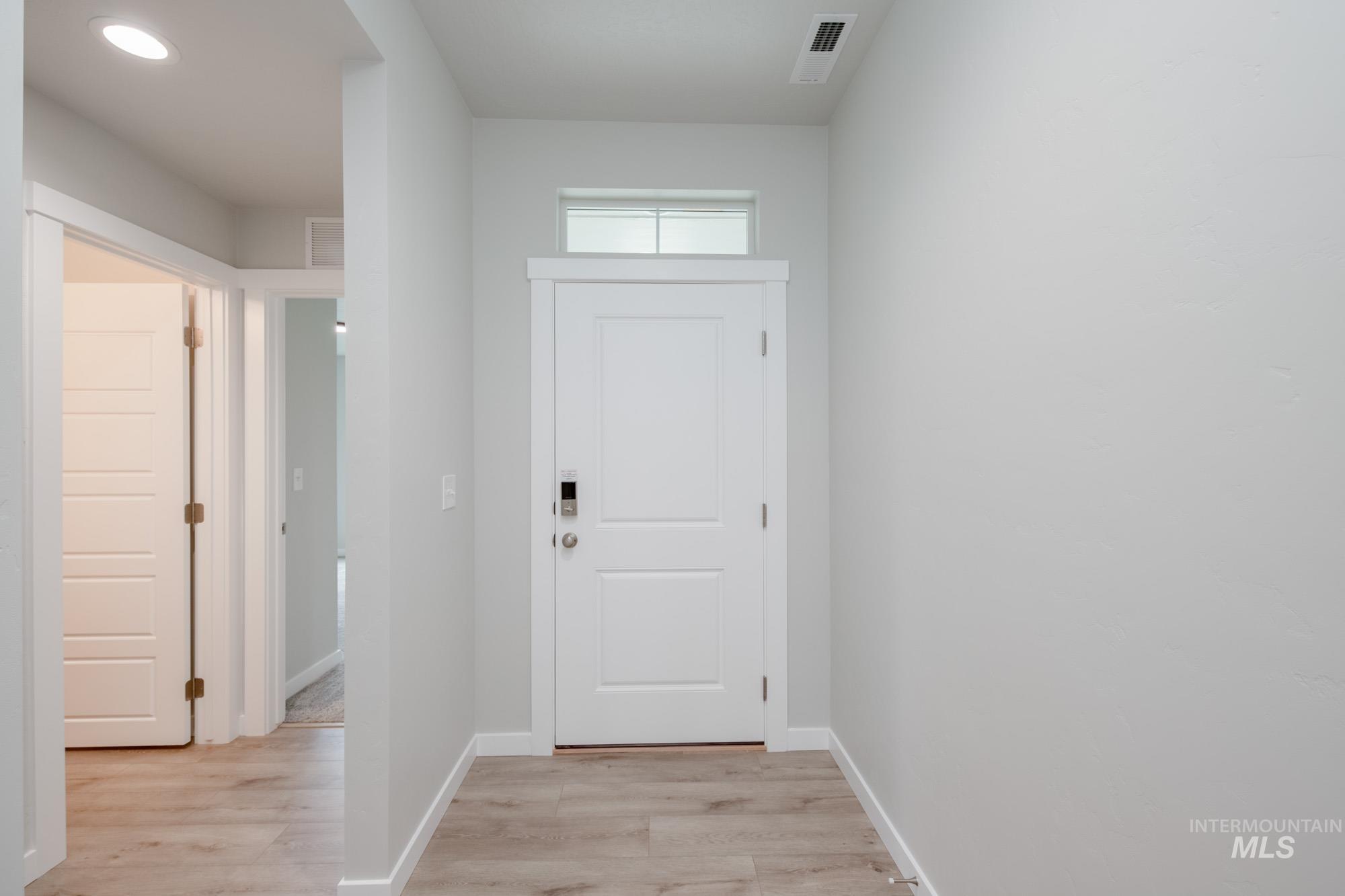 Entryway with wood finished floors and recessed lighting