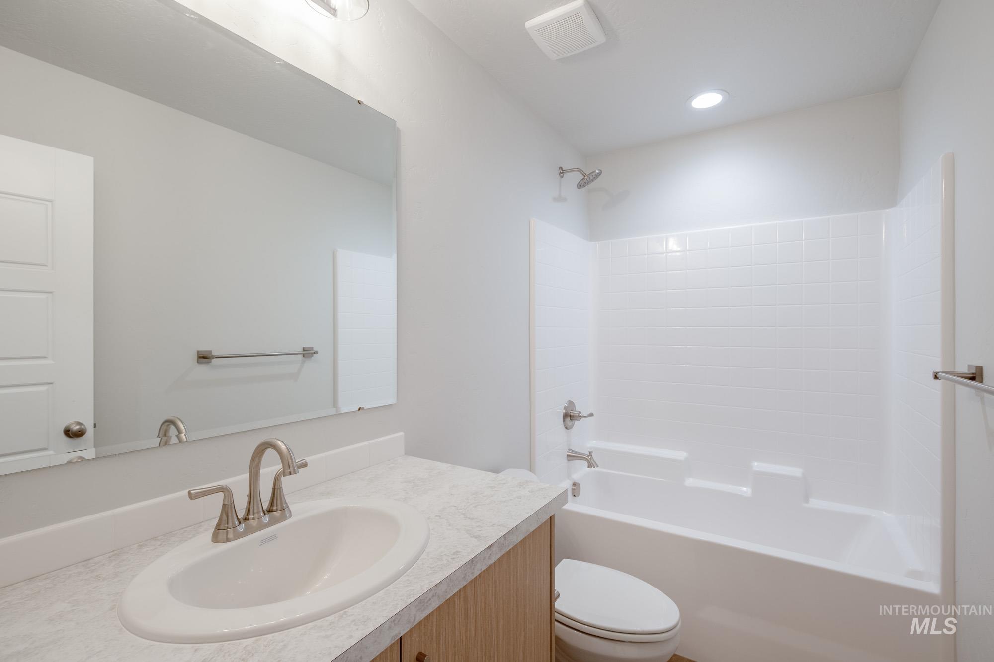 Bathroom featuring bathing tub / shower combination, vanity, and recessed lighting