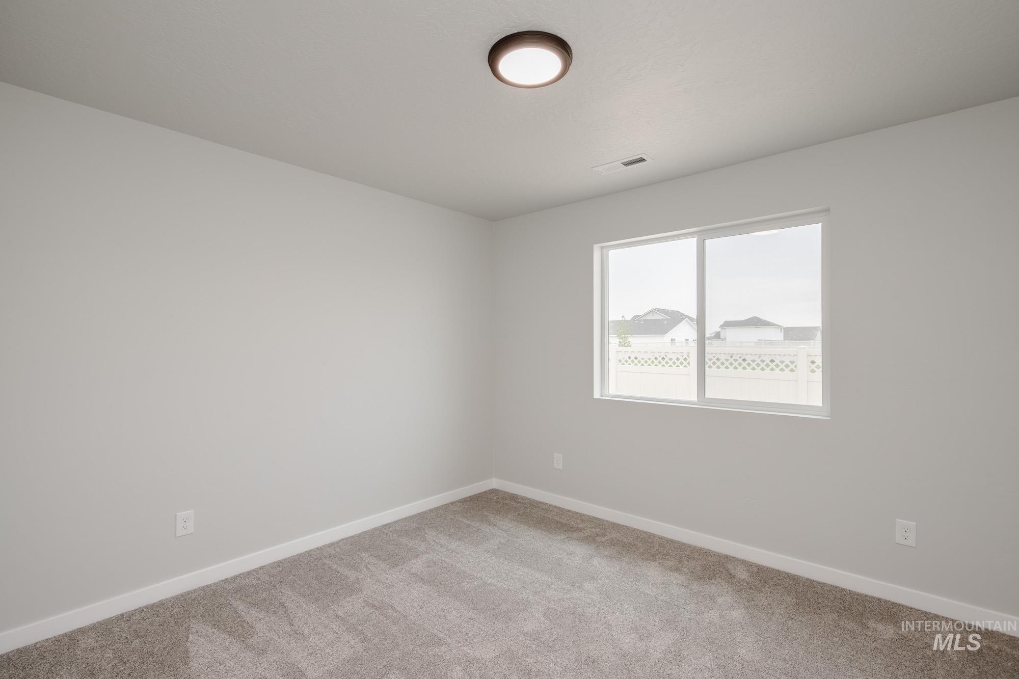 Unfurnished room with light colored carpet and baseboards