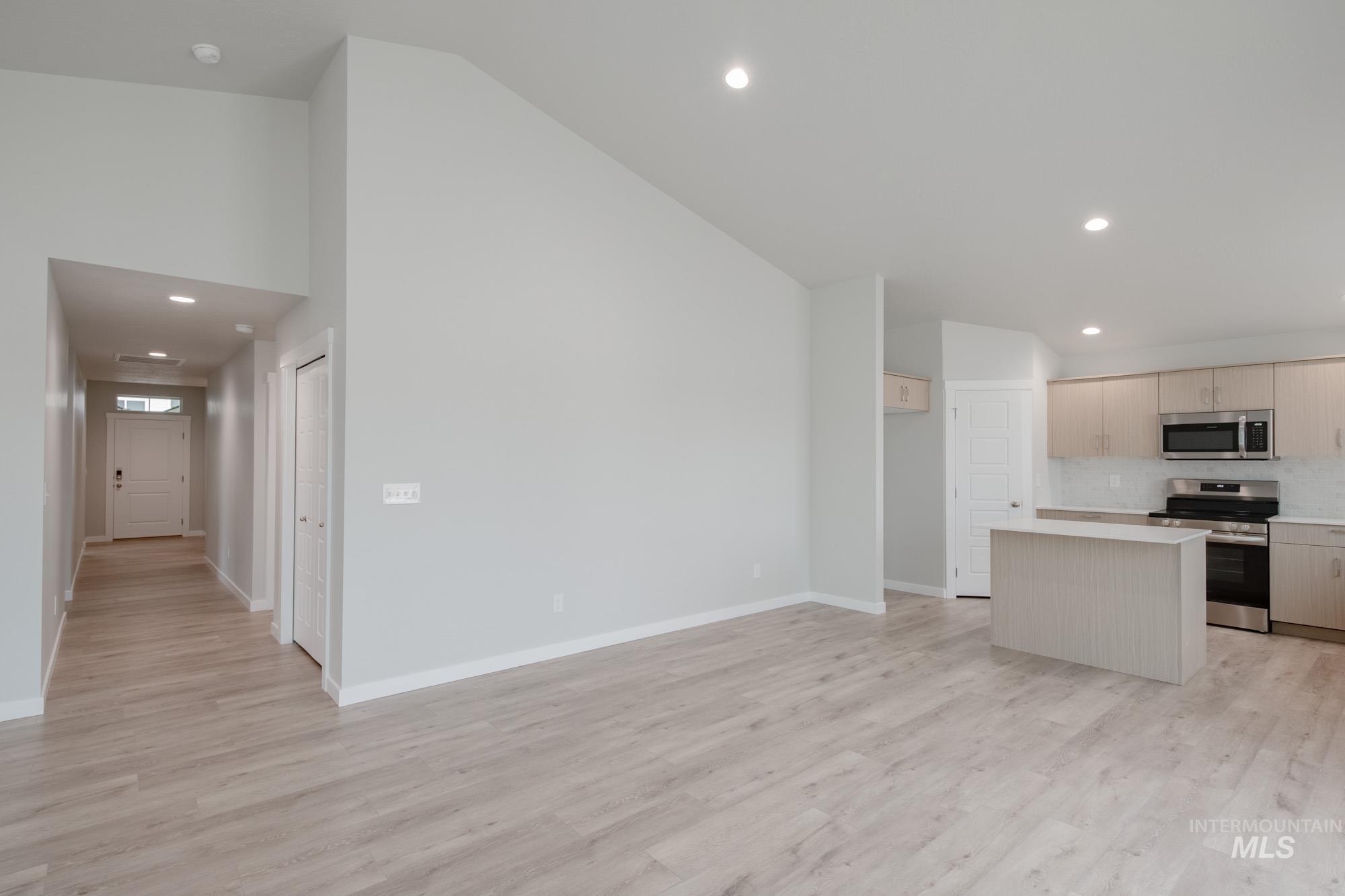 Kitchen with recessed lighting, a center island, light countertops, stainless steel appliances, and light wood-type flooring