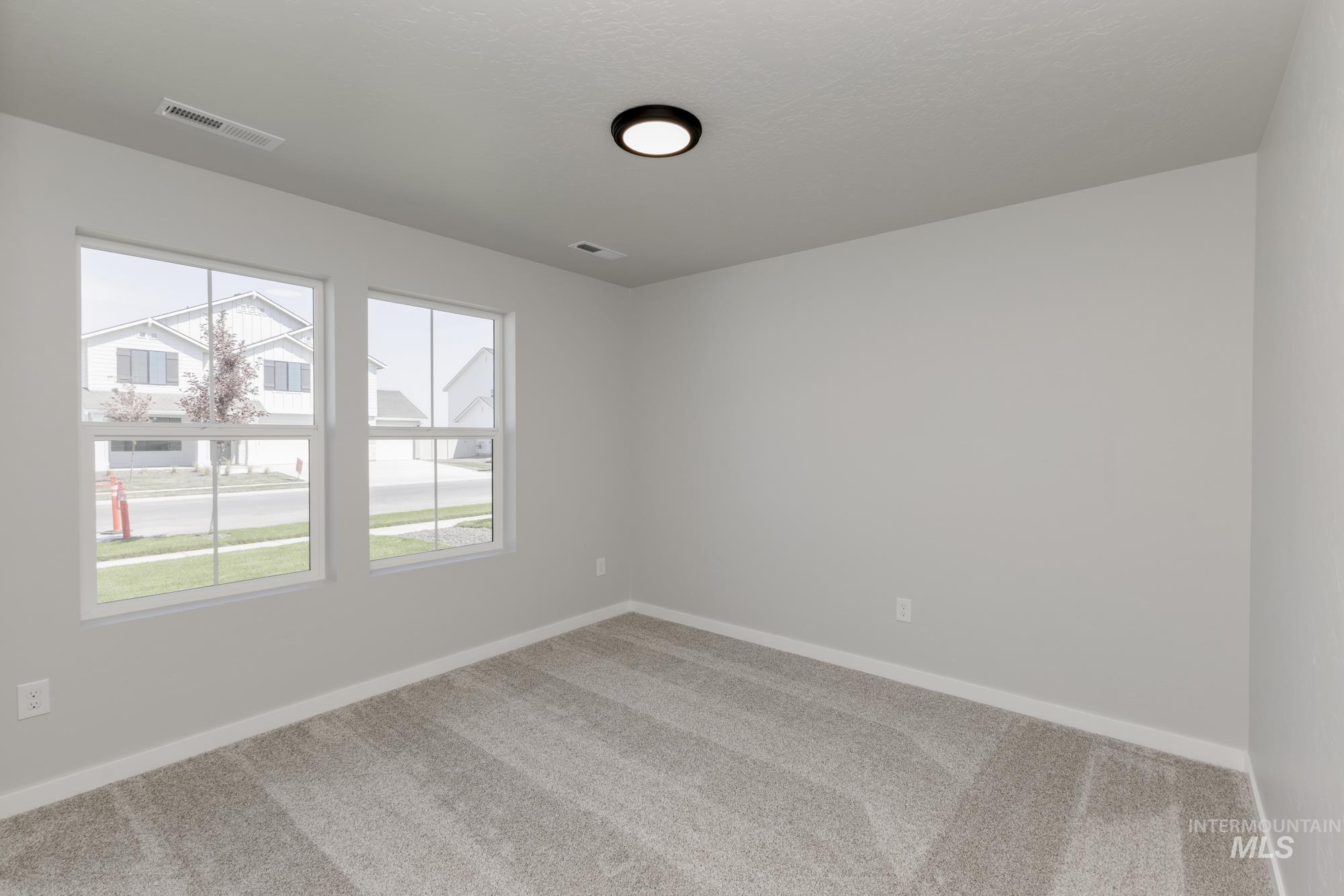 Empty room featuring carpet and baseboards