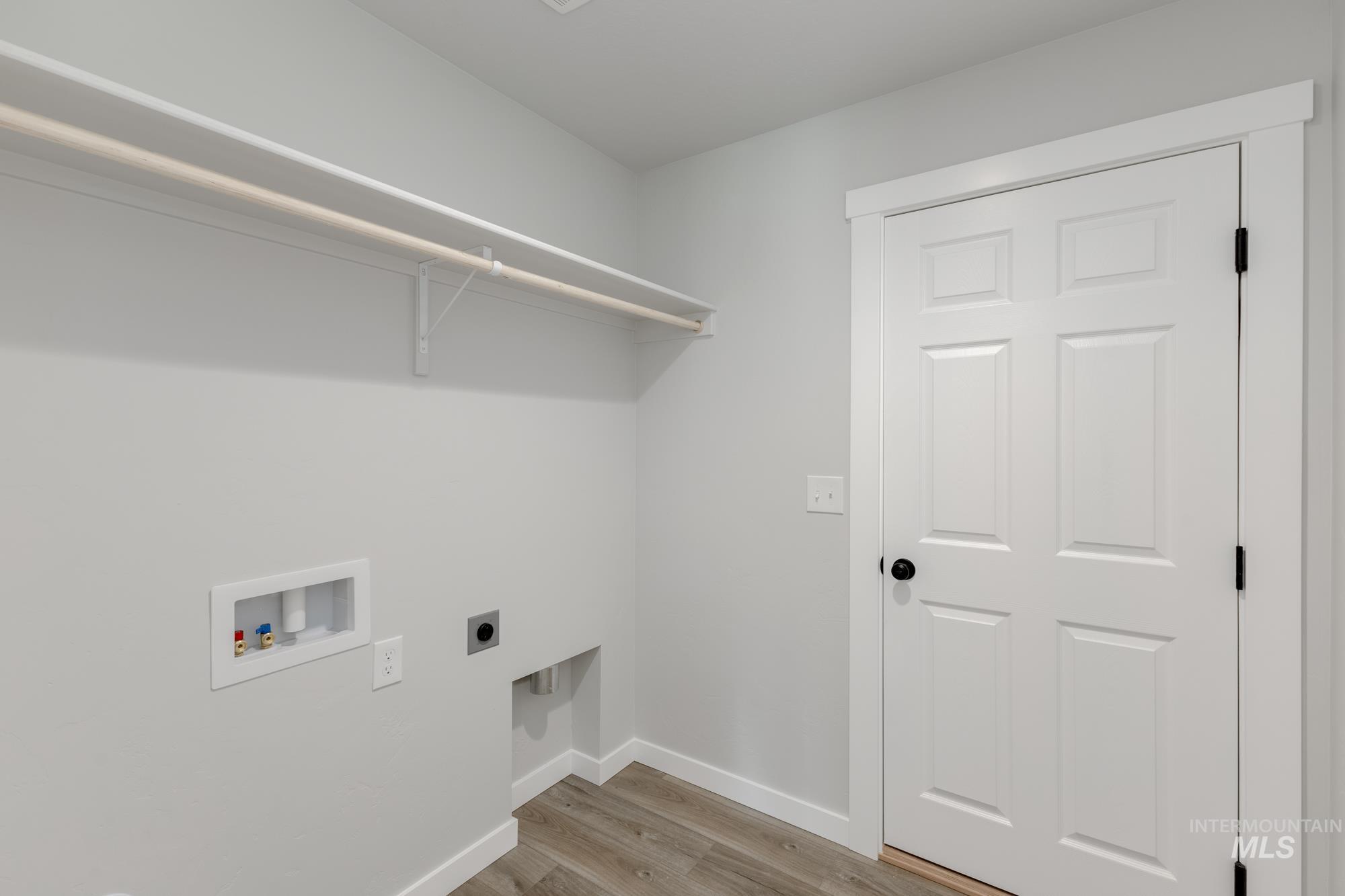 Washroom with light wood-style flooring, electric dryer hookup, and hookup for a washing machine
